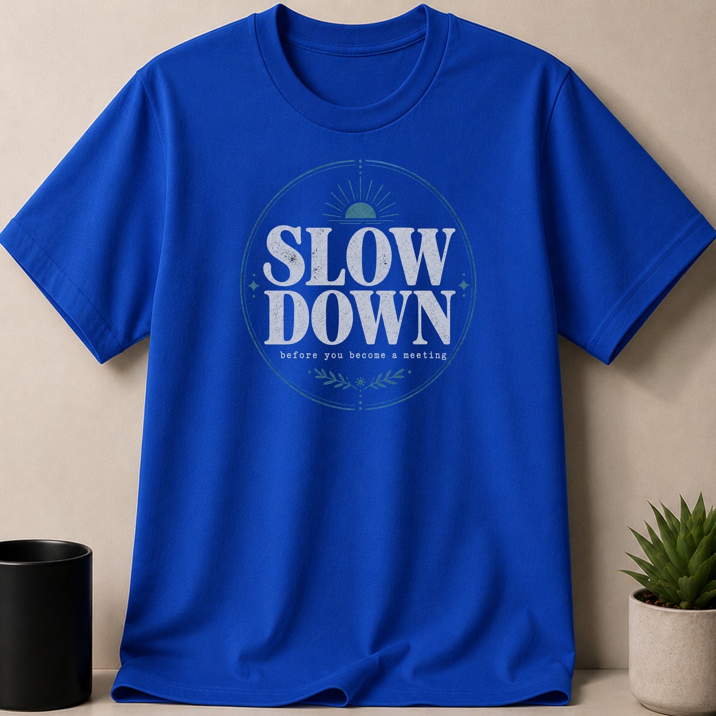 Royal blue t-shirt with "Slow Down Before You Become A Meeting" text graphic.