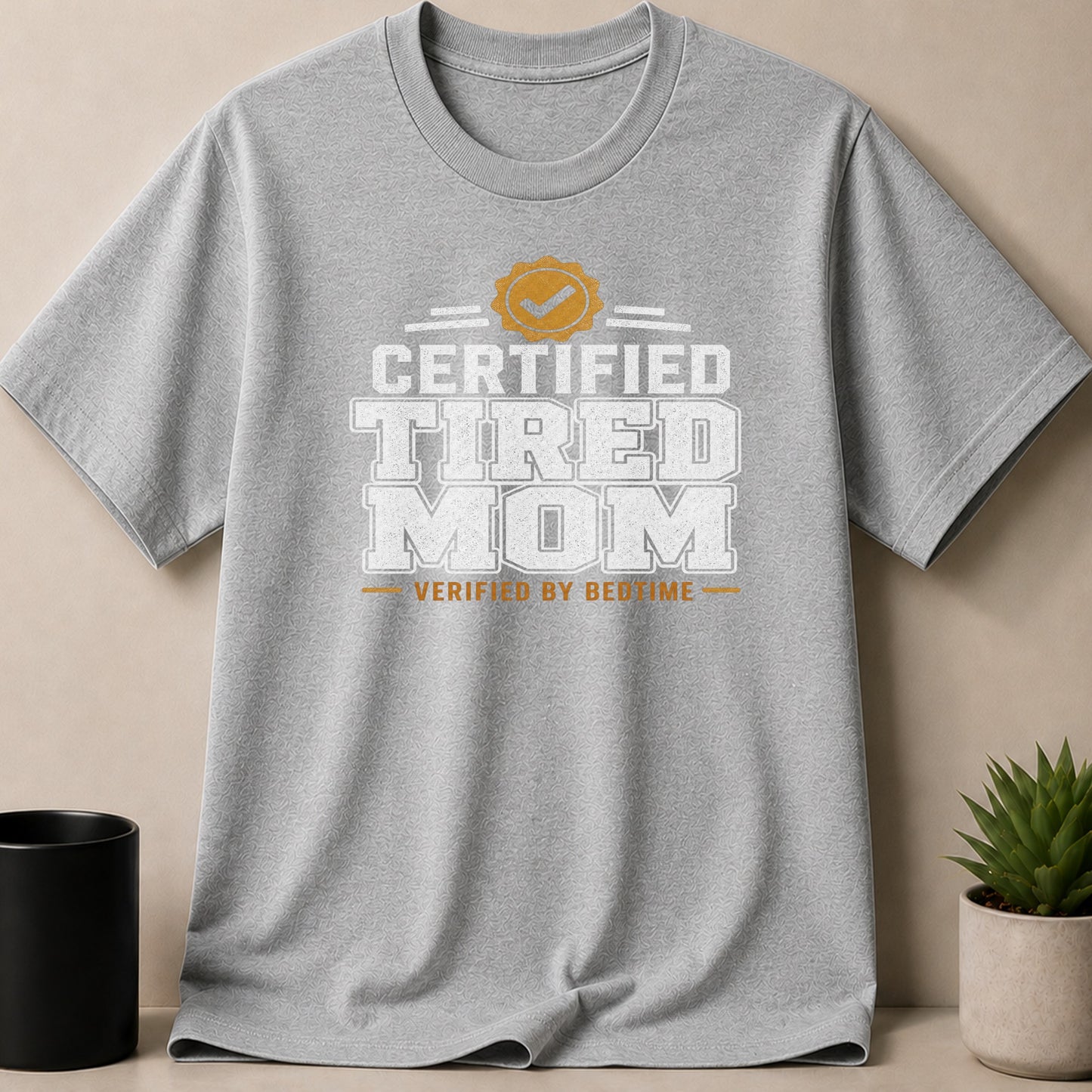 Gray t-shirt with "Certified Tired Mom Verified by Bedtime" graphic.