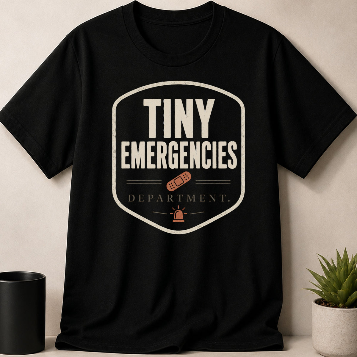 Black T-shirt with "Tiny Emergencies Department" text and medical icons.