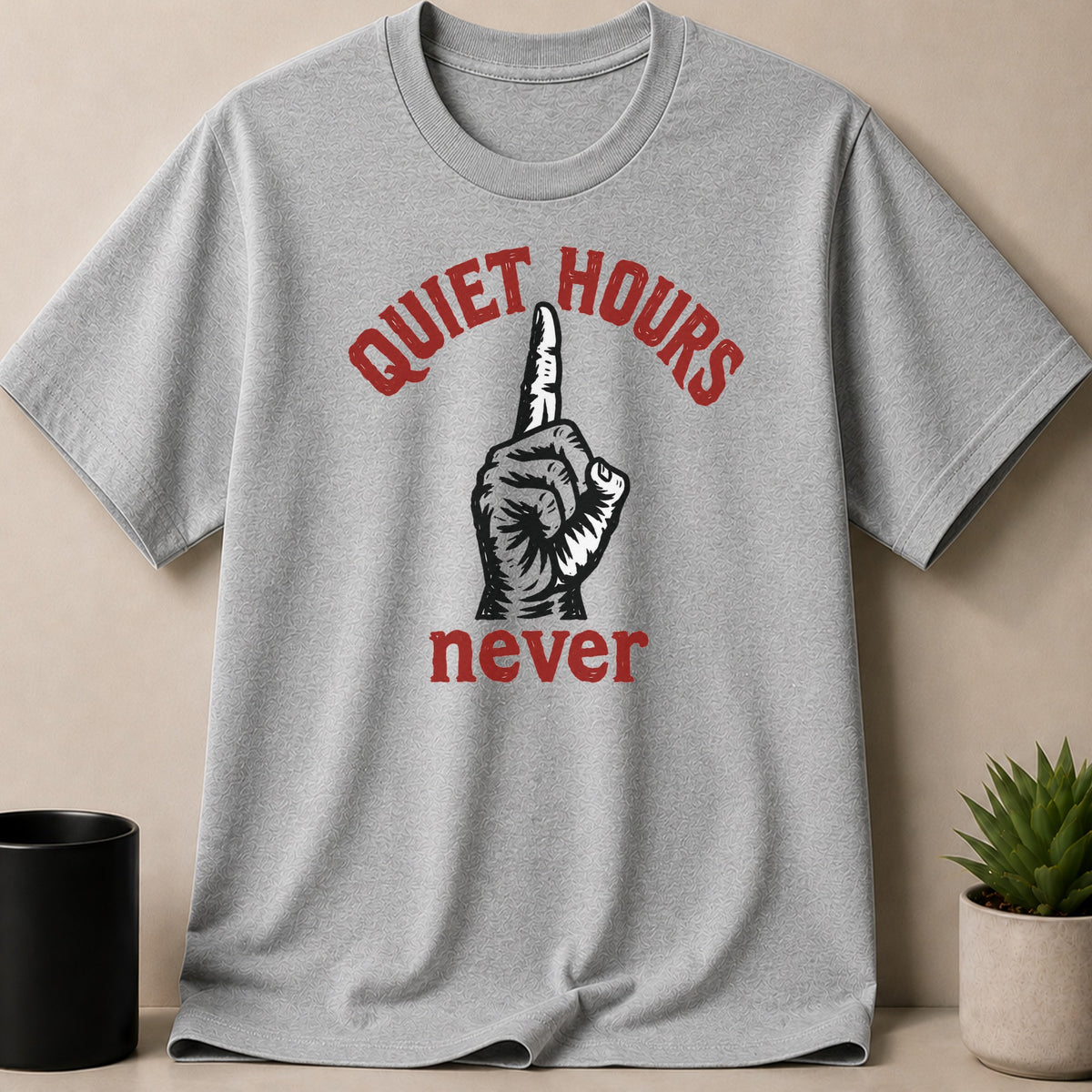 Grey t-shirt with text "QUIET HOURS never" and a finger pointing up.