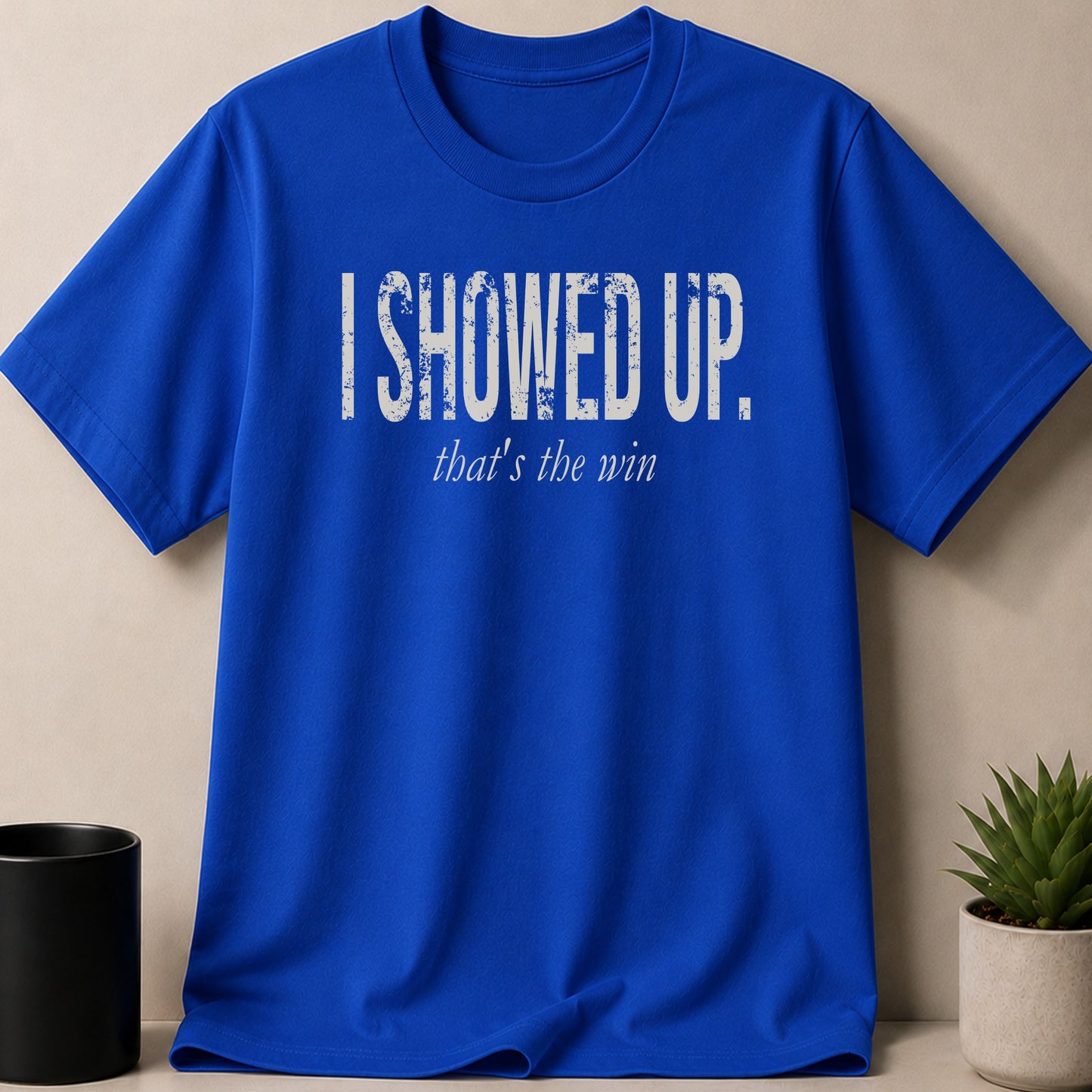 Blue t-shirt with distressed white text: "I SHOWED UP. that's the win."