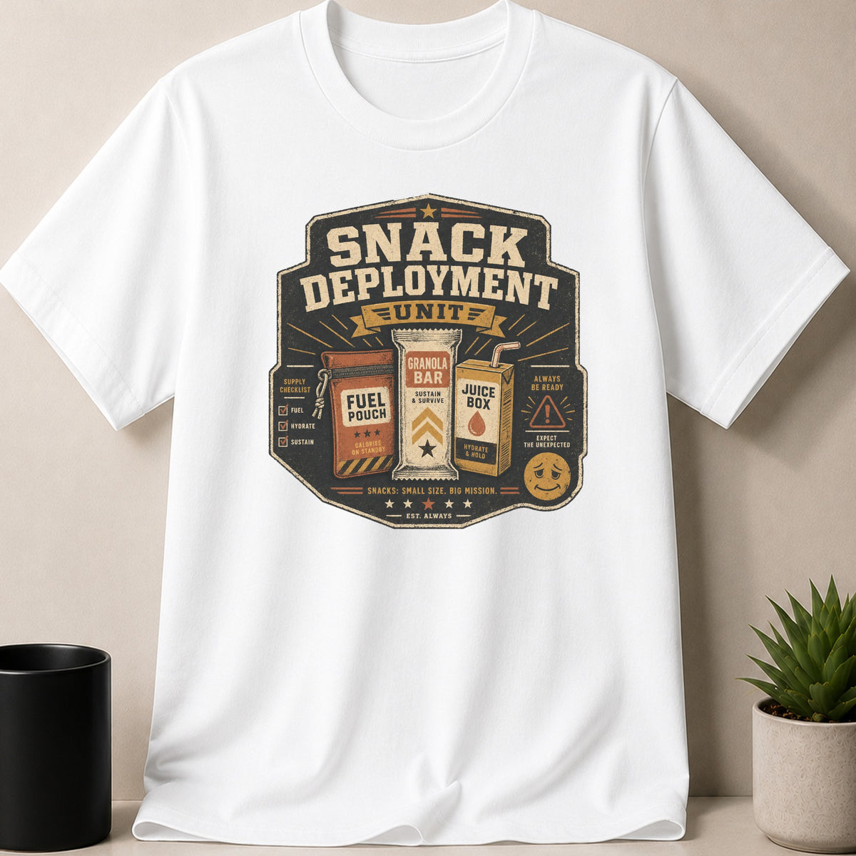 White t-shirt with a "Snack Deployment Unit" graphic featuring snacks and mission slogans.
