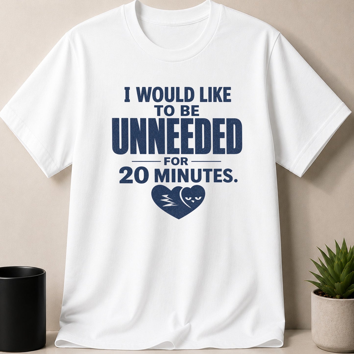 White t-shirt with navy text "I WOULD LIKE TO BE UNNEEDED FOR 20 MINUTES." and a heart graphic.