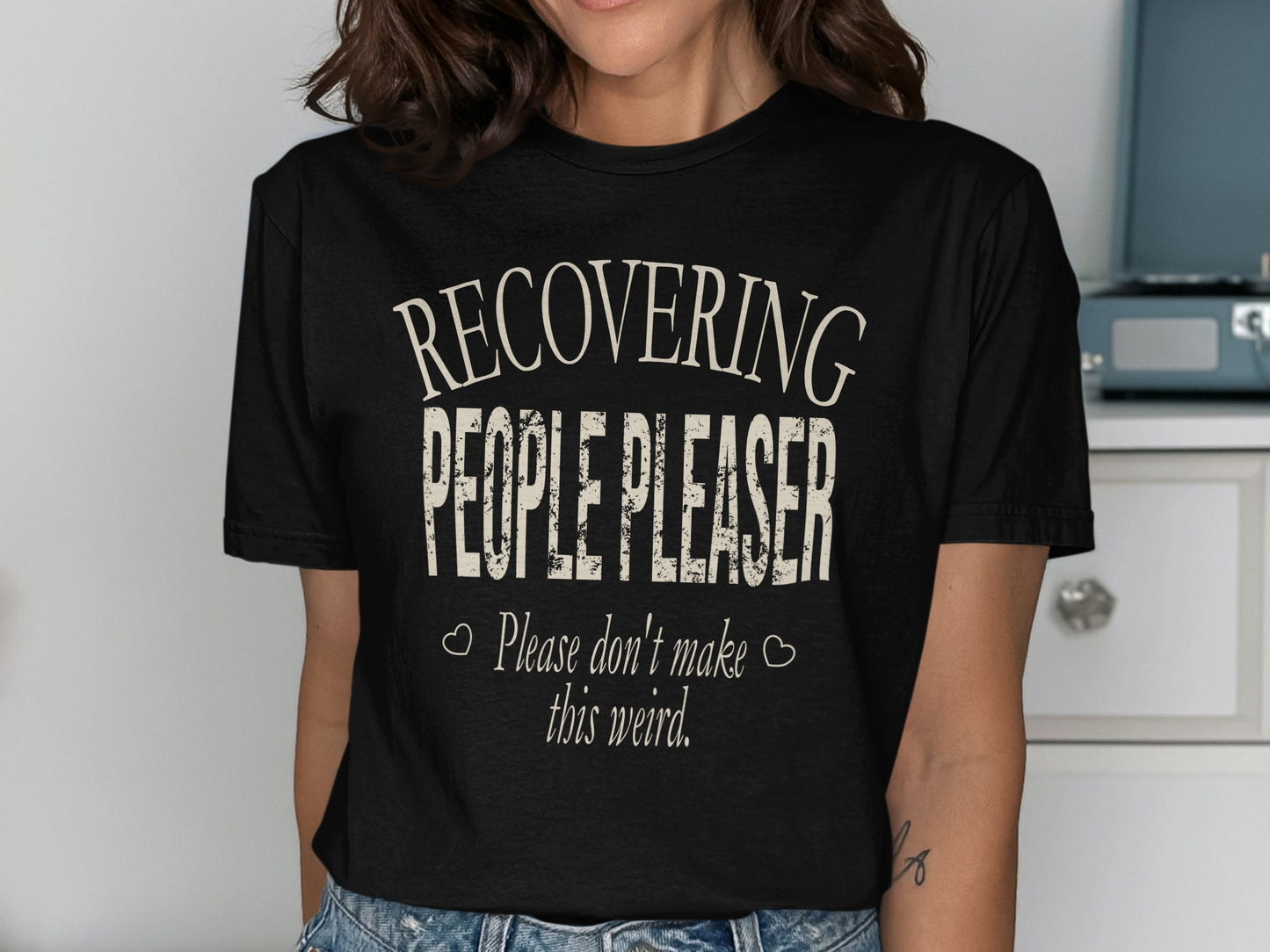 Black t-shirt with text: "RECOVERING PEOPLE PLEASER. Please don't make this weird."