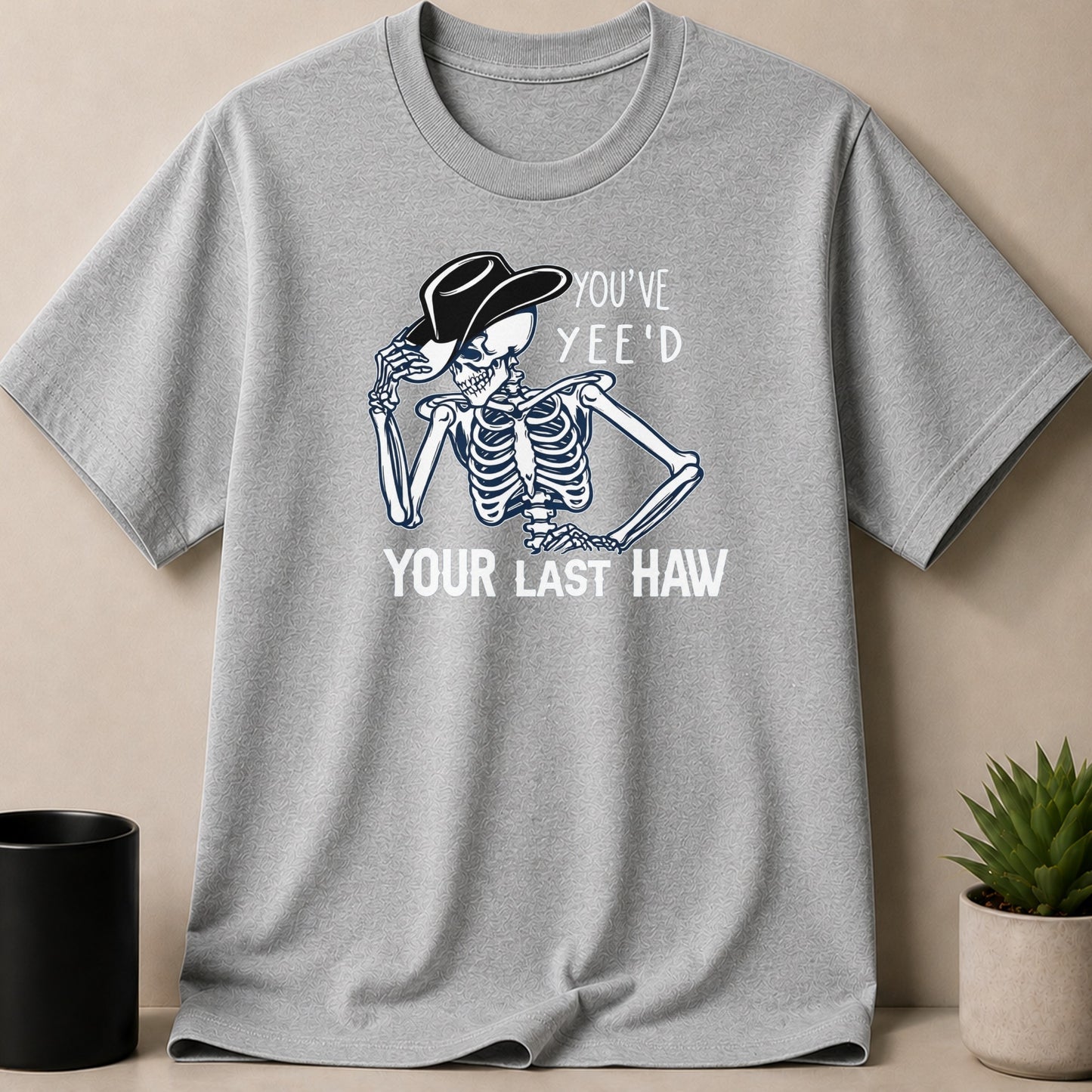 Grey t-shirt with skeleton wearing cowboy hat, text "YOU'VE YEE'D YOUR LAST HAW".