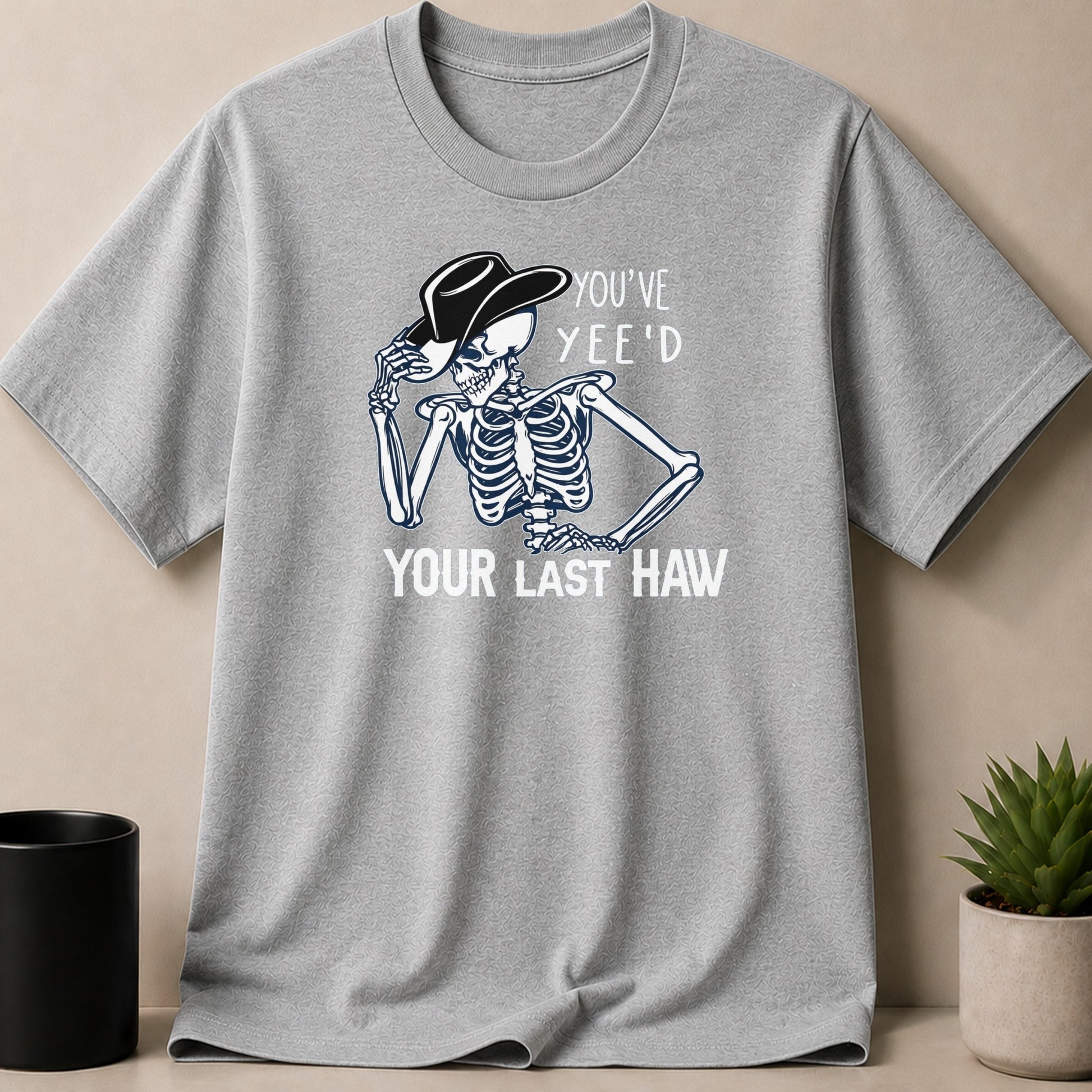 Grey t-shirt with skeleton wearing cowboy hat, text "YOU'VE YEE'D YOUR LAST HAW".
