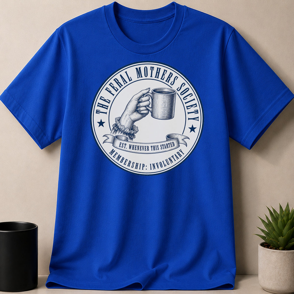 Blue t-shirt with "The Feral Mothers Society" circular graphic