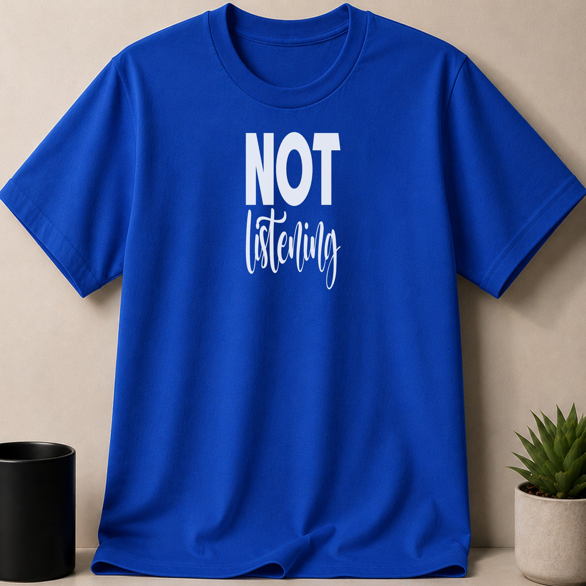 Blue t-shirt with white text reading "NOT listening".