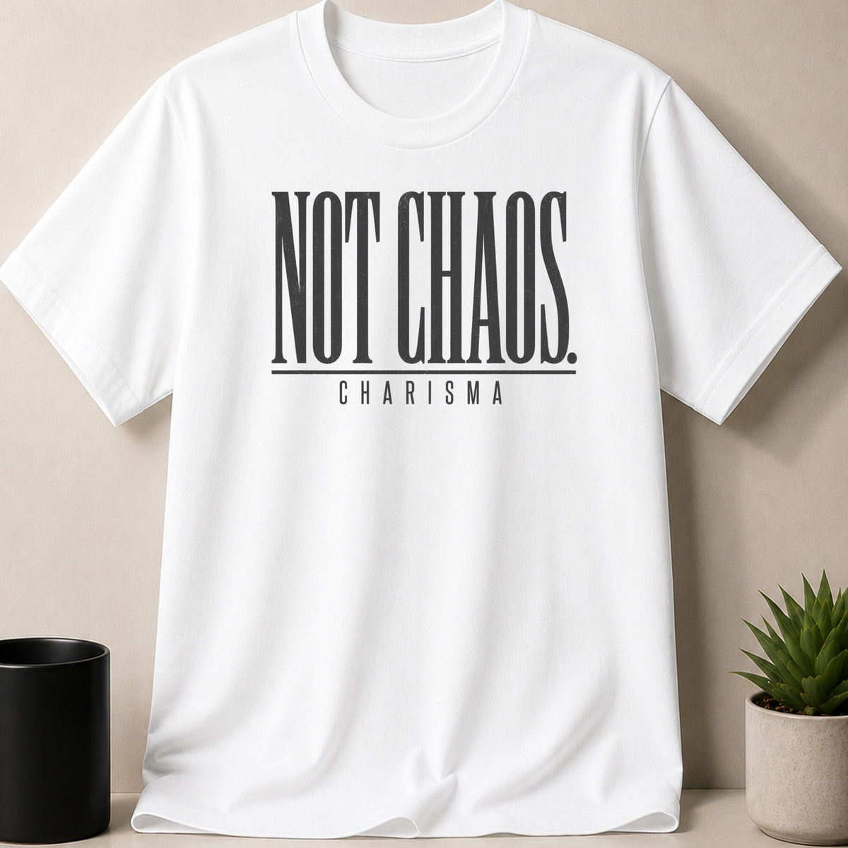 White t-shirt with black text "NOT CHAOS" and "CHARISMA" below.