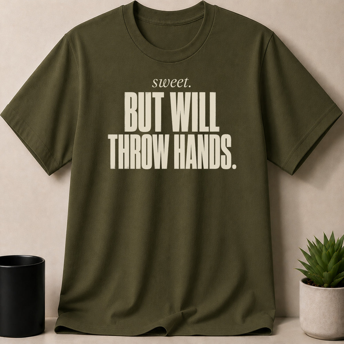Olive t-shirt with "sweet. BUT WILL THROW HANDS." text graphic.