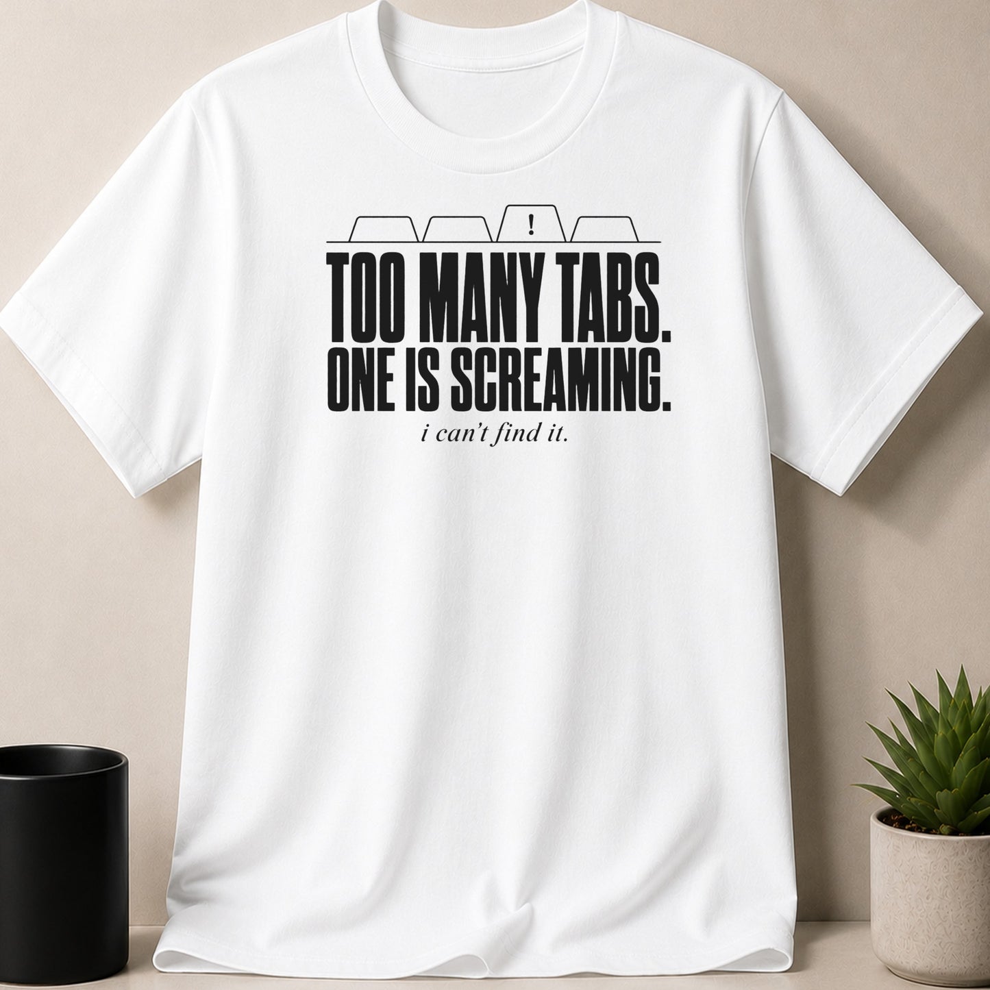 White t-shirt with black text reading "TOO MANY TABS. ONE IS SCREAMING. i can't find it."