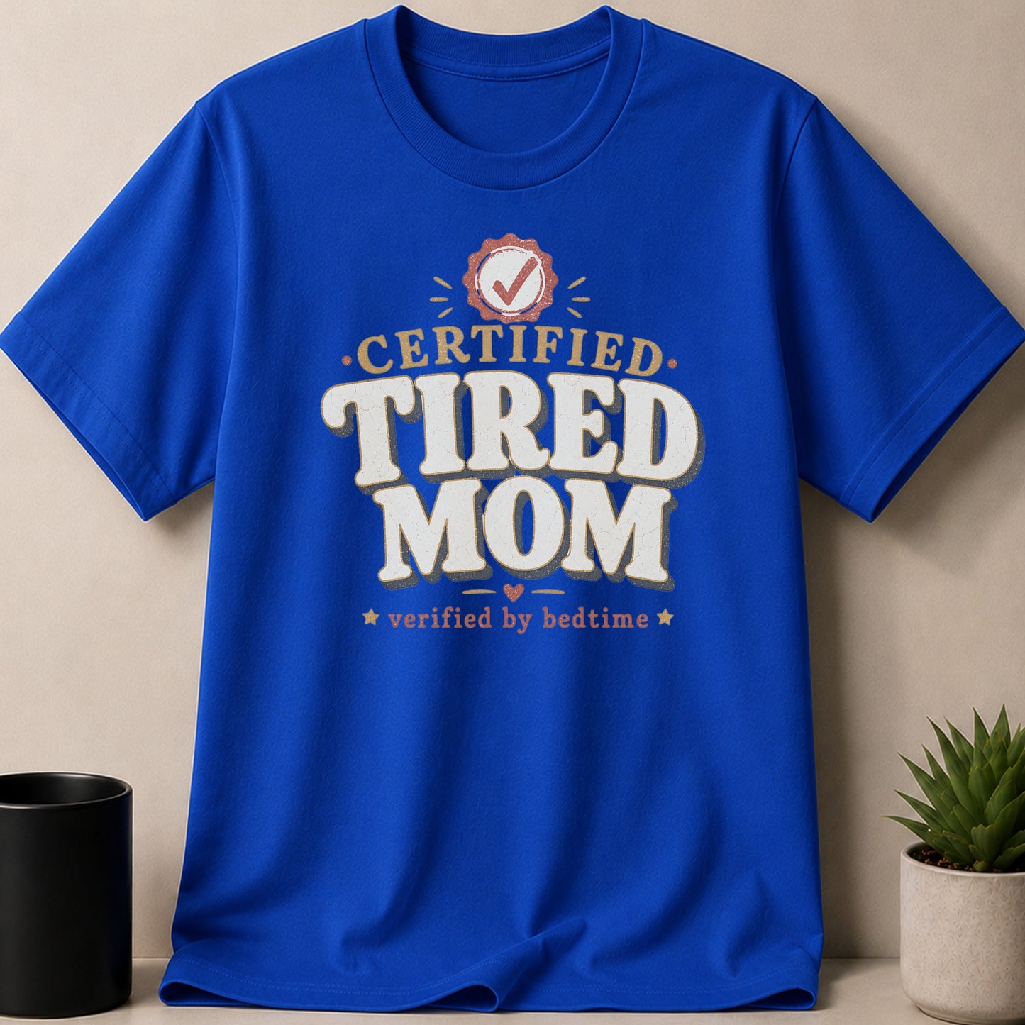 Blue t-shirt with "Certified Tired Mom Verified by Bedtime" graphic.