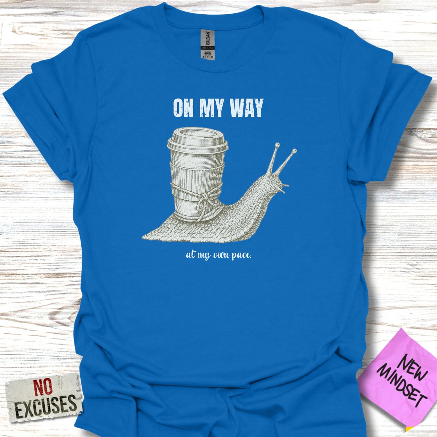 Blue t-shirt with a snail carrying a coffee cup, text "ON MY WAY at my own pace."