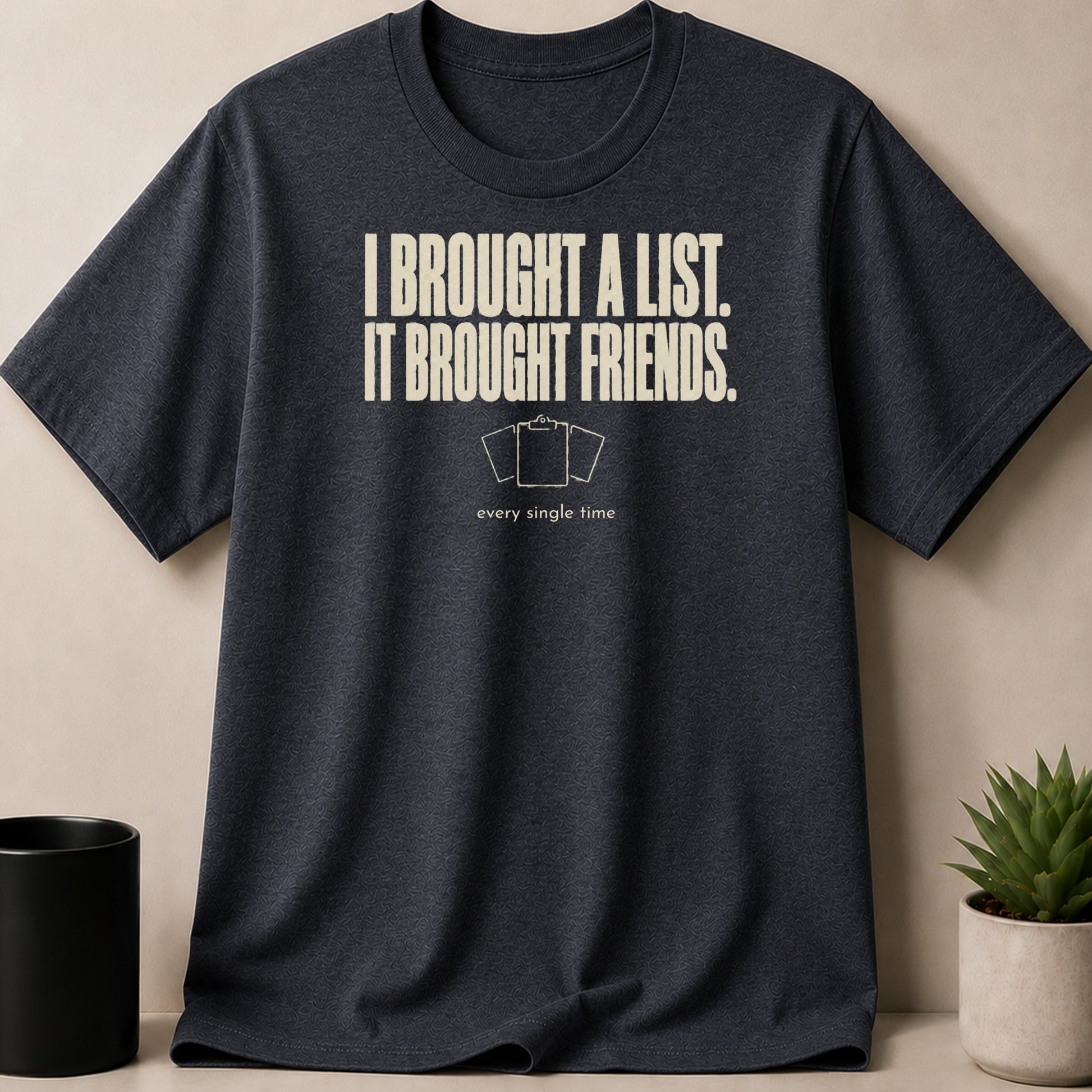 Dark t-shirt with text "I BROUGHT A LIST. IT BROUGHT FRIENDS." and graphic.