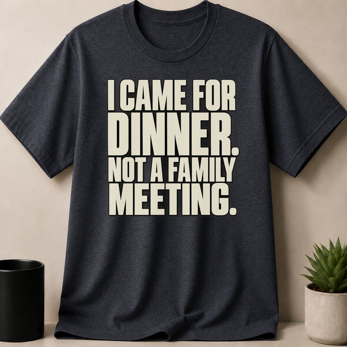 A dark gray t-shirt featuring the text I CAME FOR DINNER. NOT A FAMILY MEETING. in cream letters.