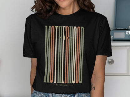 Black t-shirt features "MOTHERHOOD" in vertical, colorful stripes with "terms apply."