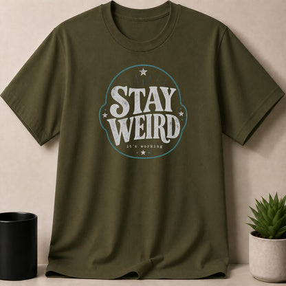 Olive green t-shirt with "STAY WEIRD it's working" graphic.