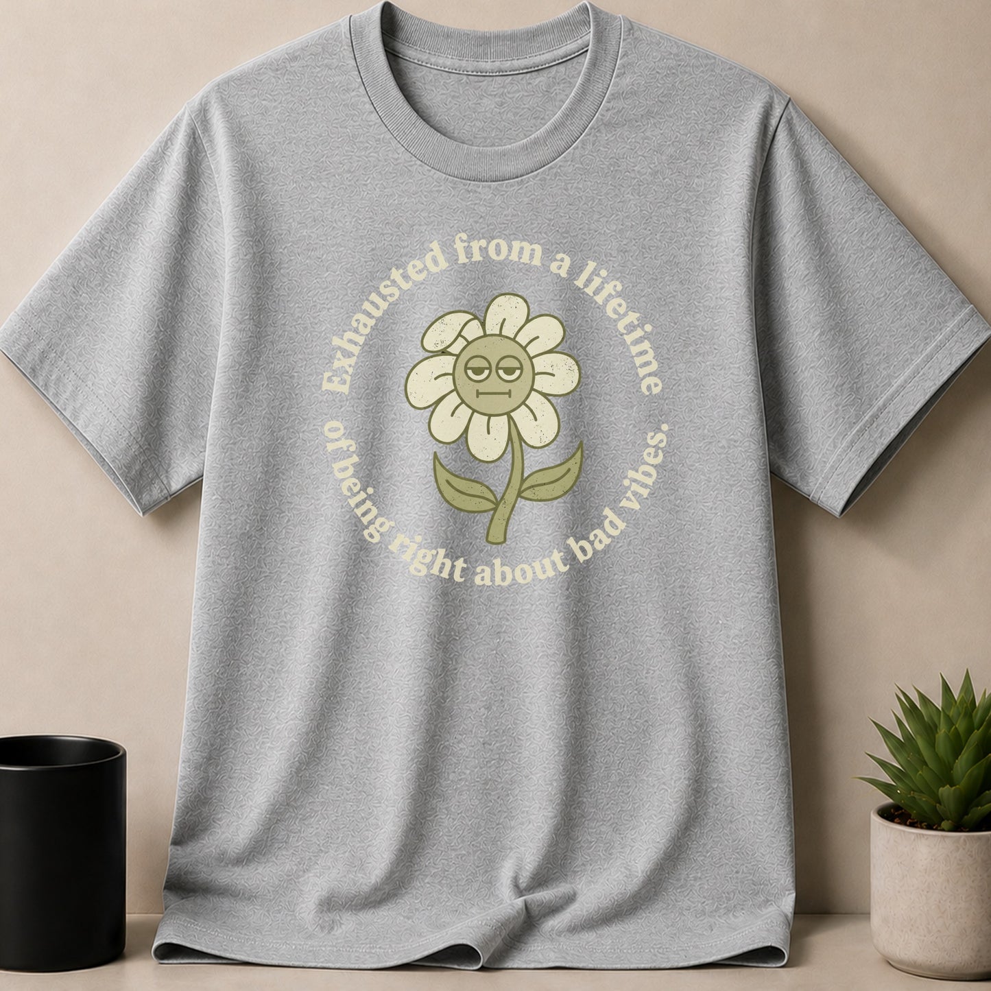 Grey t-shirt with a distressed flower graphic and text: "Exhausted from a lifetime of being right about bad vibes."