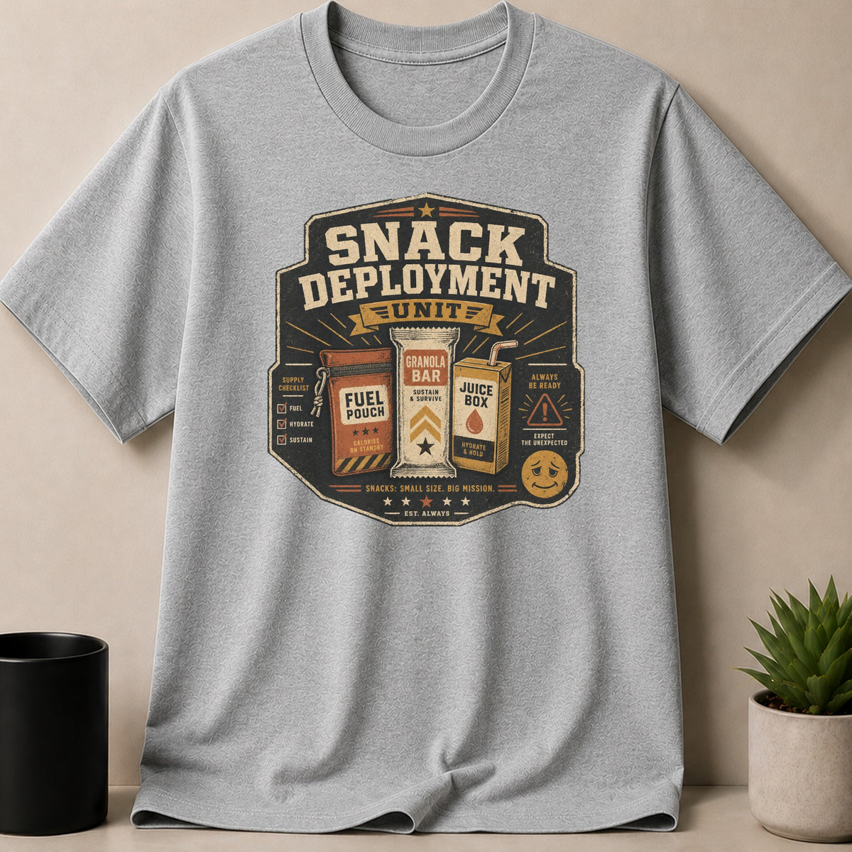 Gray t-shirt with "Snack Deployment Unit" crest featuring snacks and mission checklist.