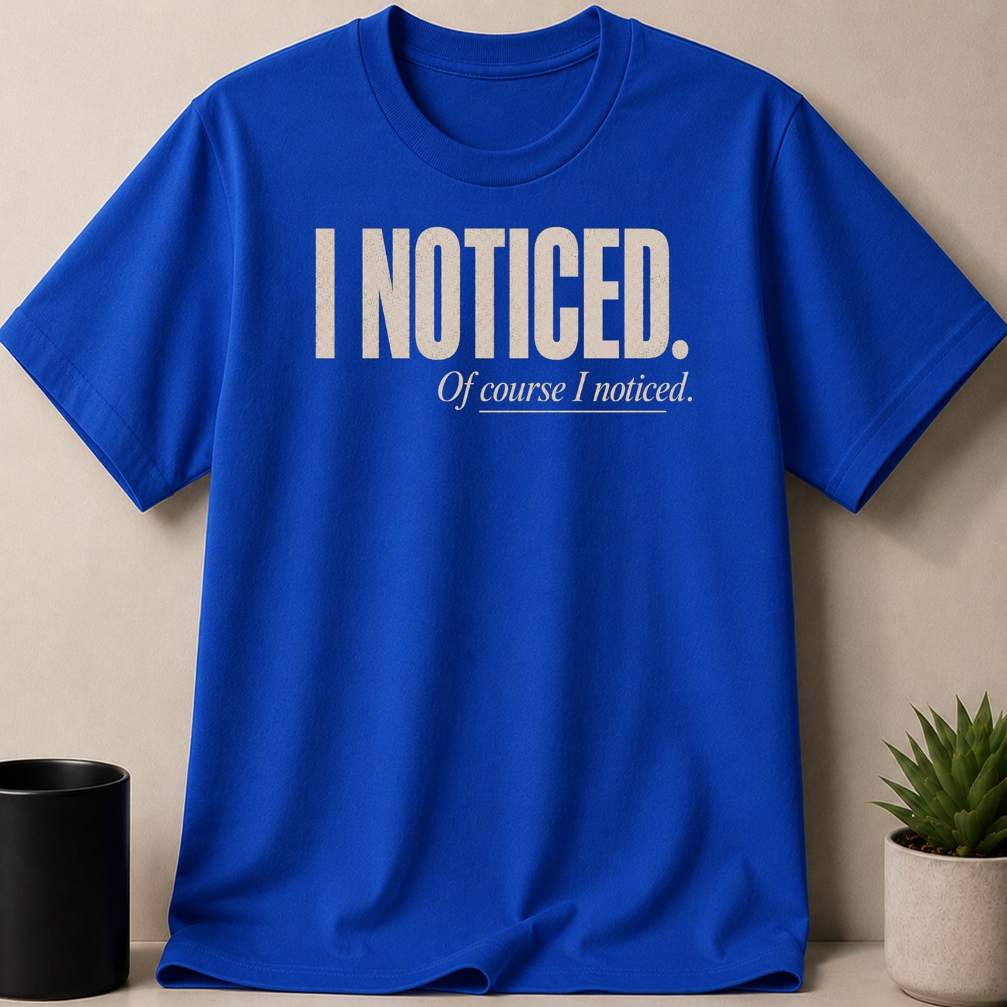 Royal blue t-shirt with cream text reading "I NOTICED. Of course I noticed."