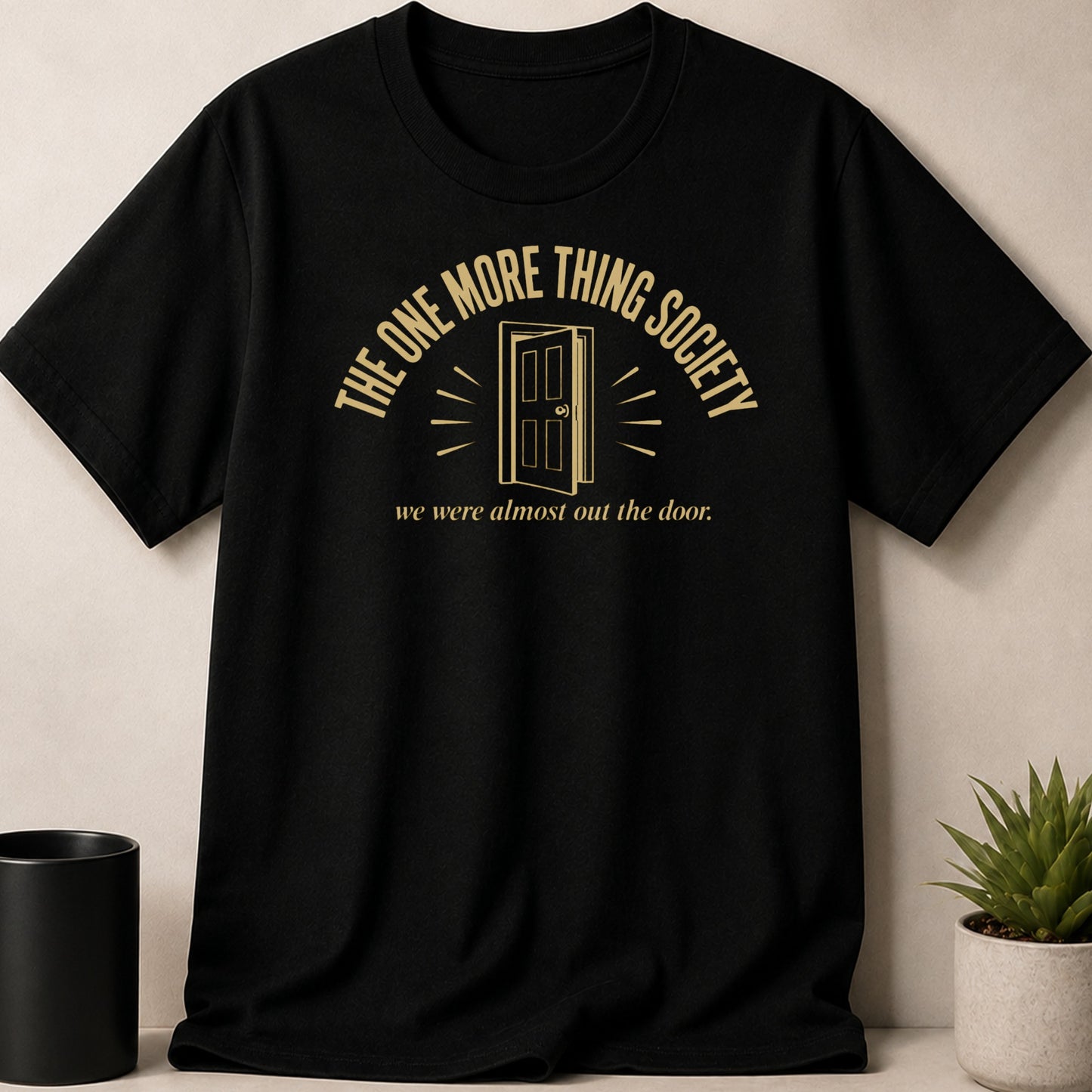 Black t-shirt with gold text: "The One More Thing Society" and "we were almost out the door."