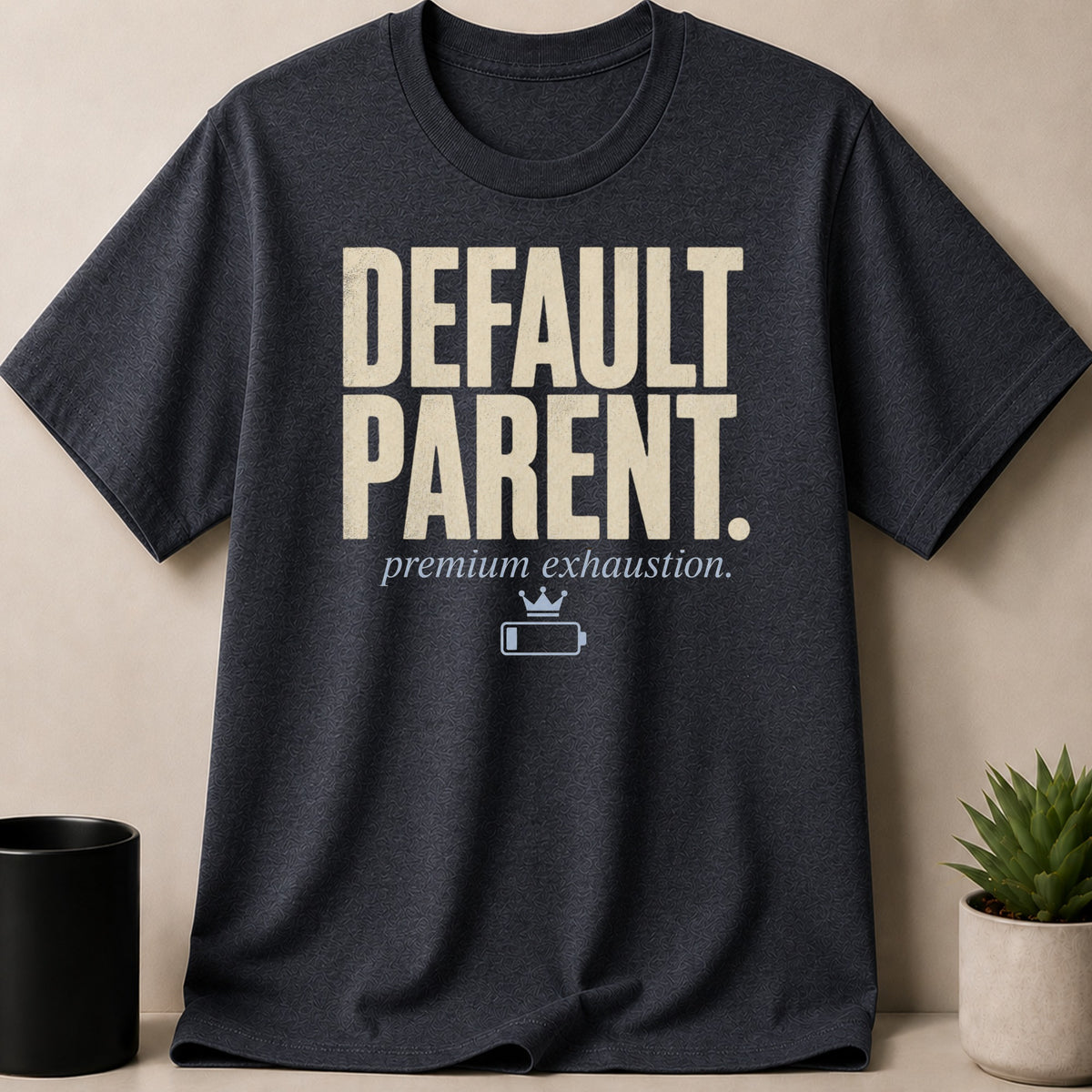 Dark t-shirt with "DEFAULT PARENT. premium exhaustion." and a low battery icon.