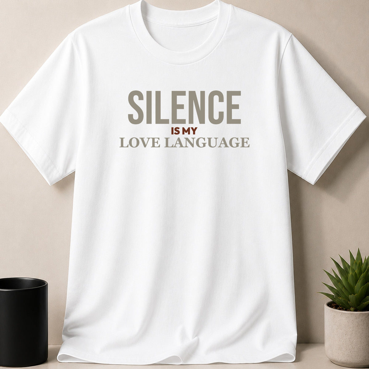 A white t-shirt printed with the text SILENCE IS MY LOVE LANGUAGE laid flat against a neutral background.