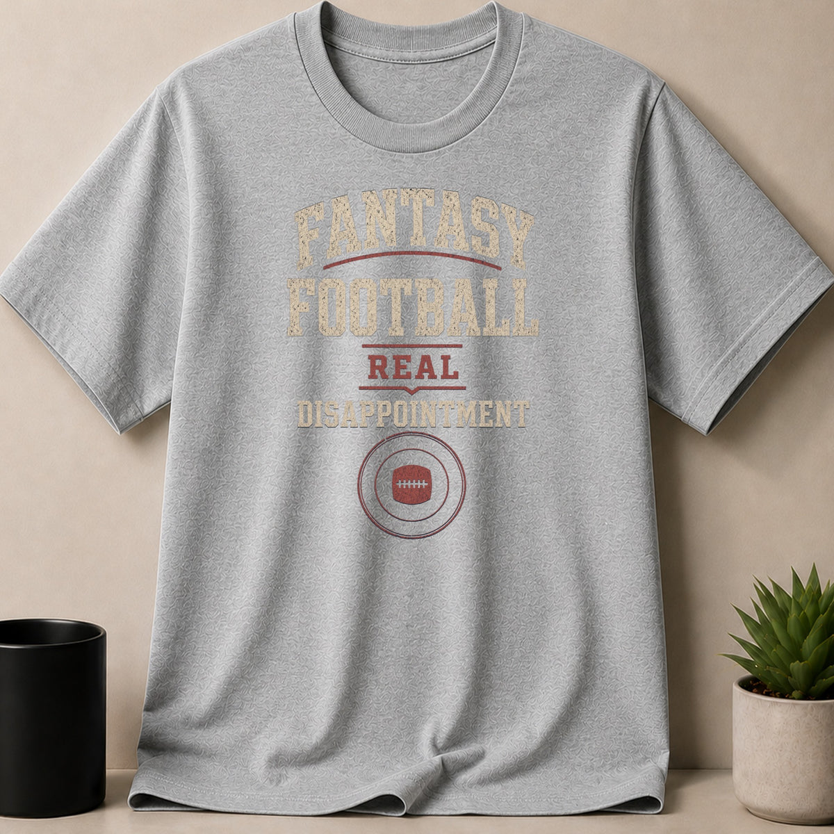 Grey t-shirt with text "Fantasy Football Real Disappointment" and football graphic.