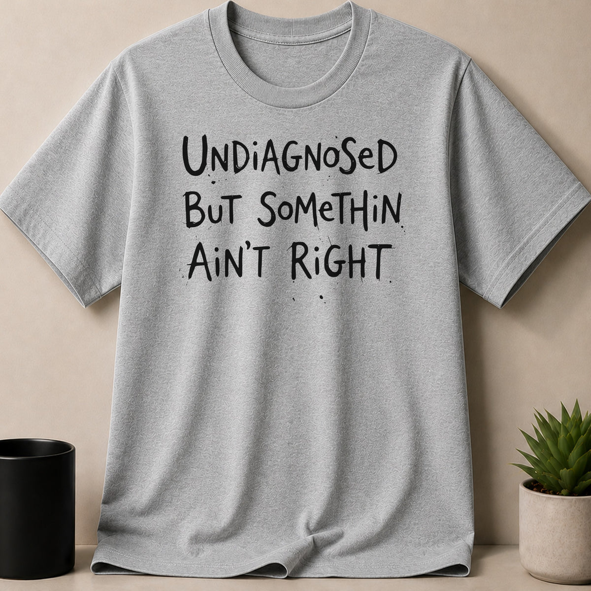 Gray t-shirt with black text reading "UNDIAGNOSED BUT SOMETHIN AIN'T RIGHT".