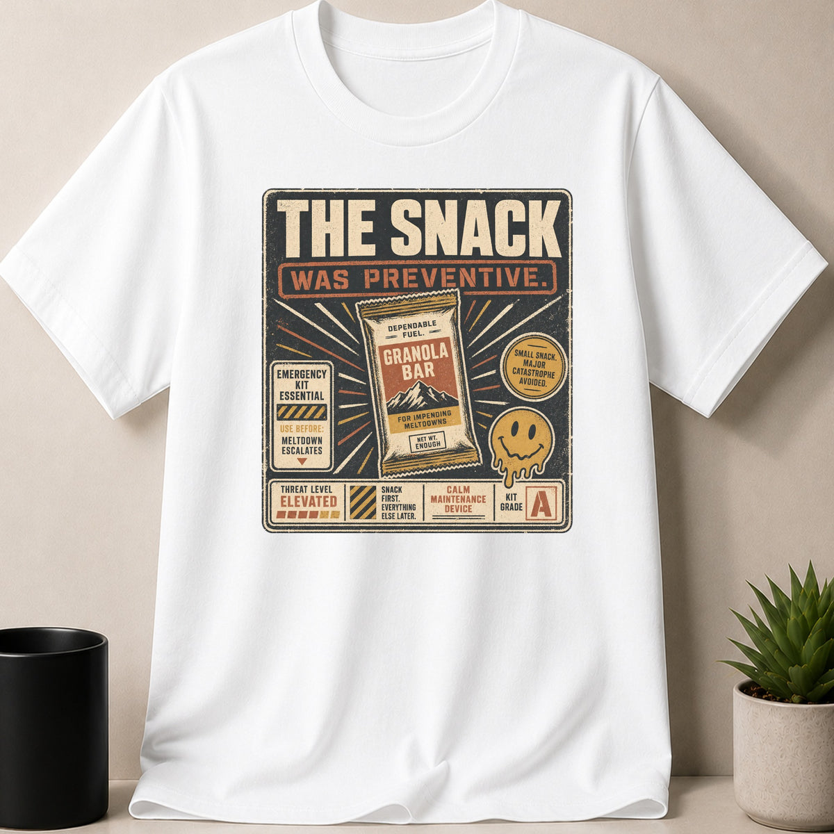 White t-shirt with "The Snack Was Preventive" graphic featuring a granola bar and smiley face.