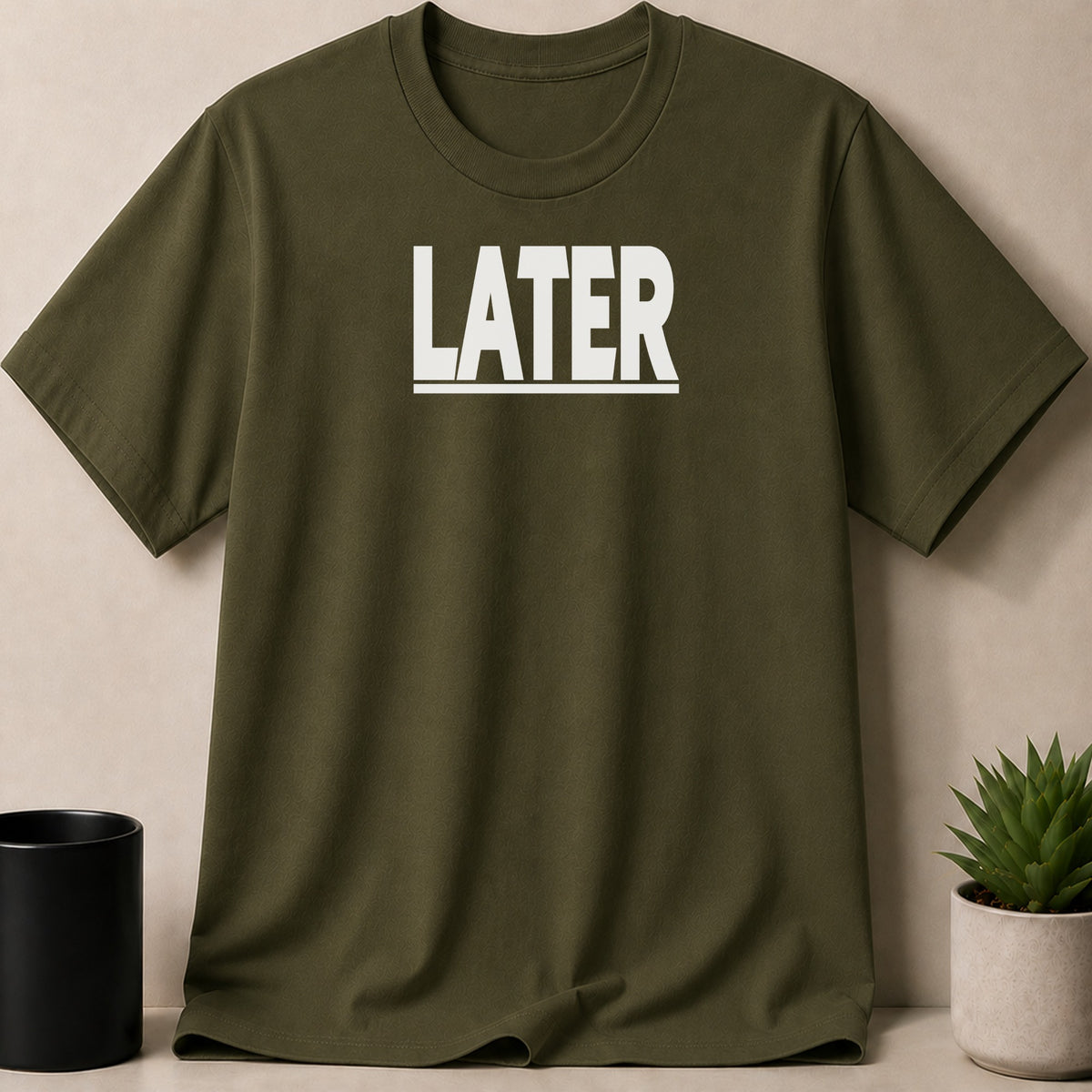 Olive green t-shirt with white "LATER" text and a subtle textured pattern.