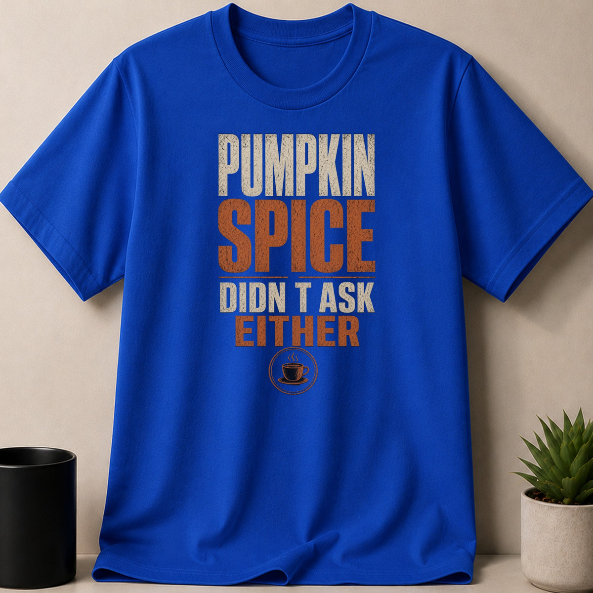 Blue t-shirt with text "Pumpkin Spice Didn't Ask Either" and coffee cup graphic.