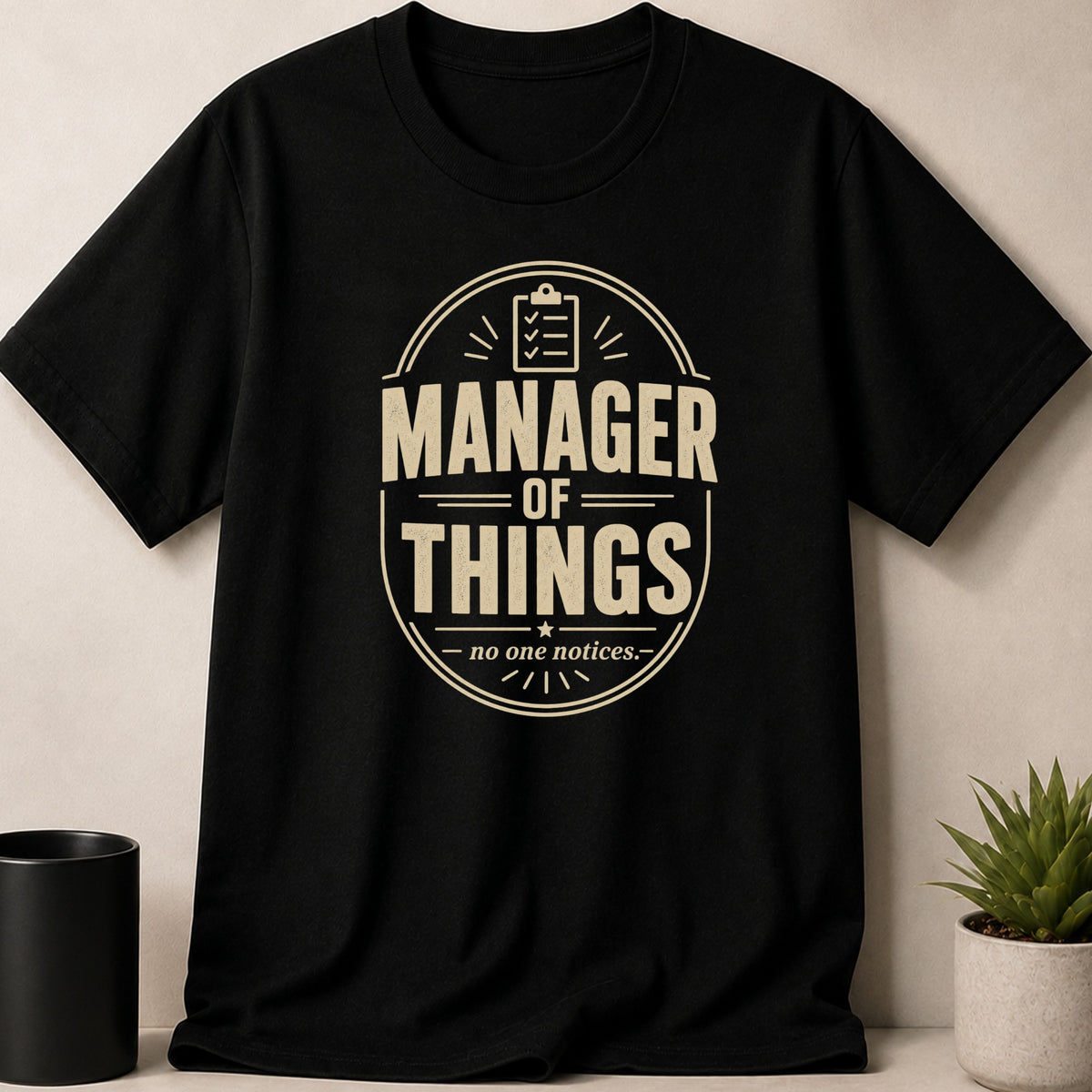 Black t-shirt with "MANAGER OF THINGS - no one notices." quote.