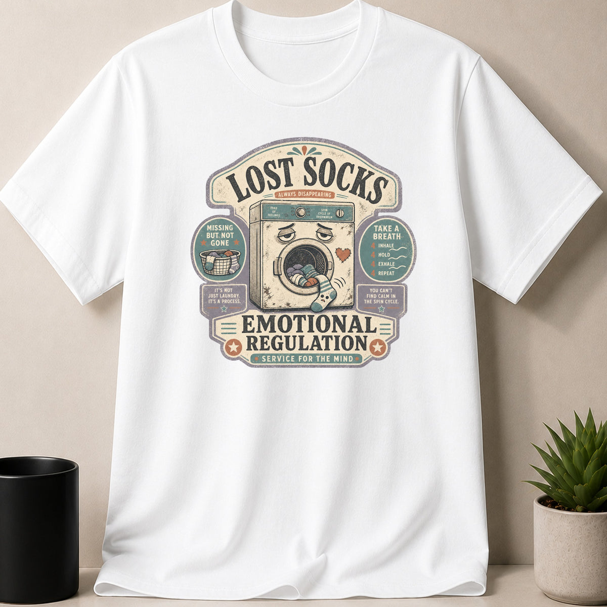 White t-shirt with "Lost Socks Emotional Regulation" graphic featuring a sad washing machine.