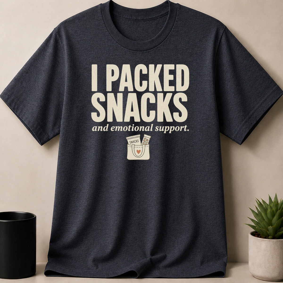 Dark t-shirt with "I PACKED SNACKS and emotional support." text and a bag graphic.