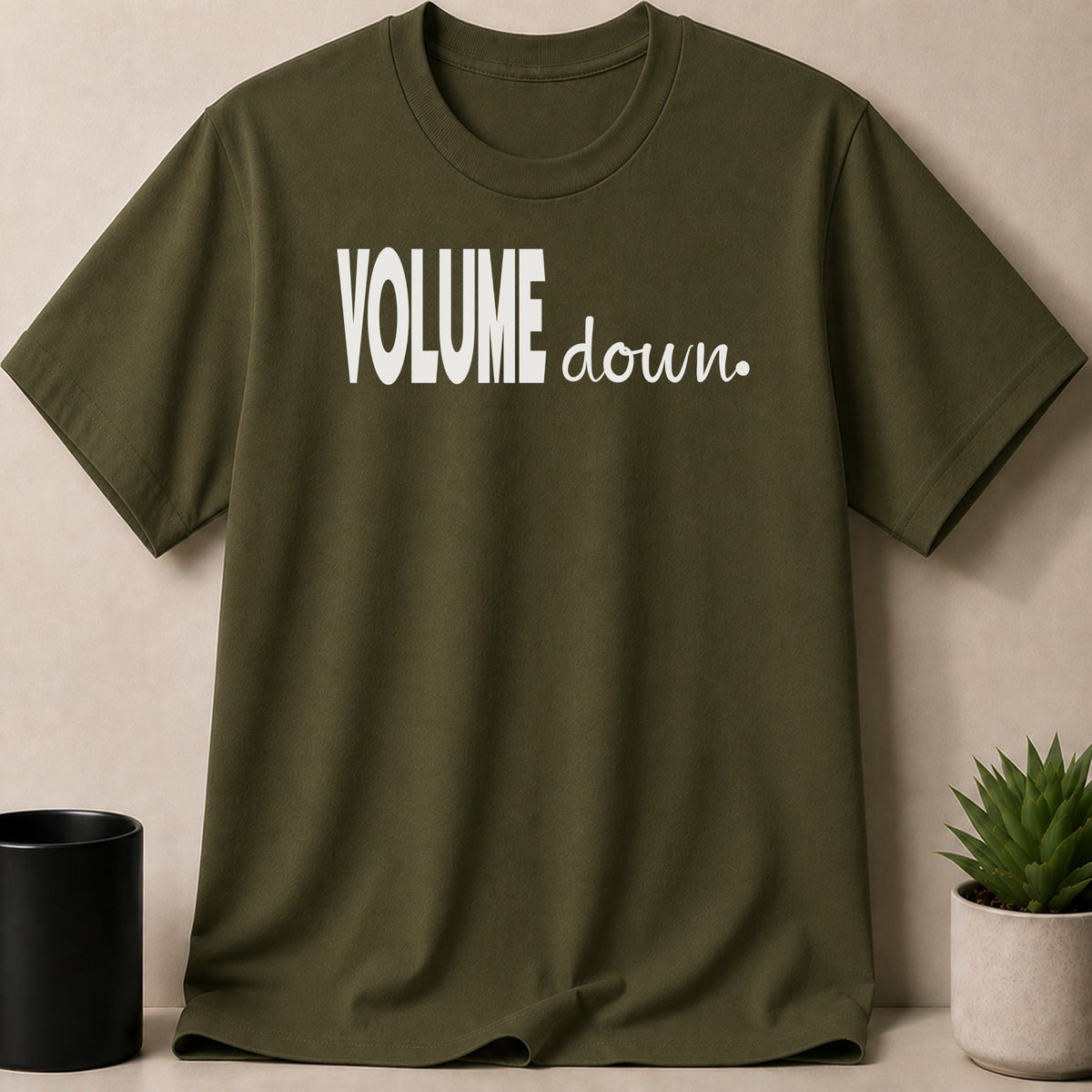Olive green t-shirt with white "VOLUME down." text on chest.