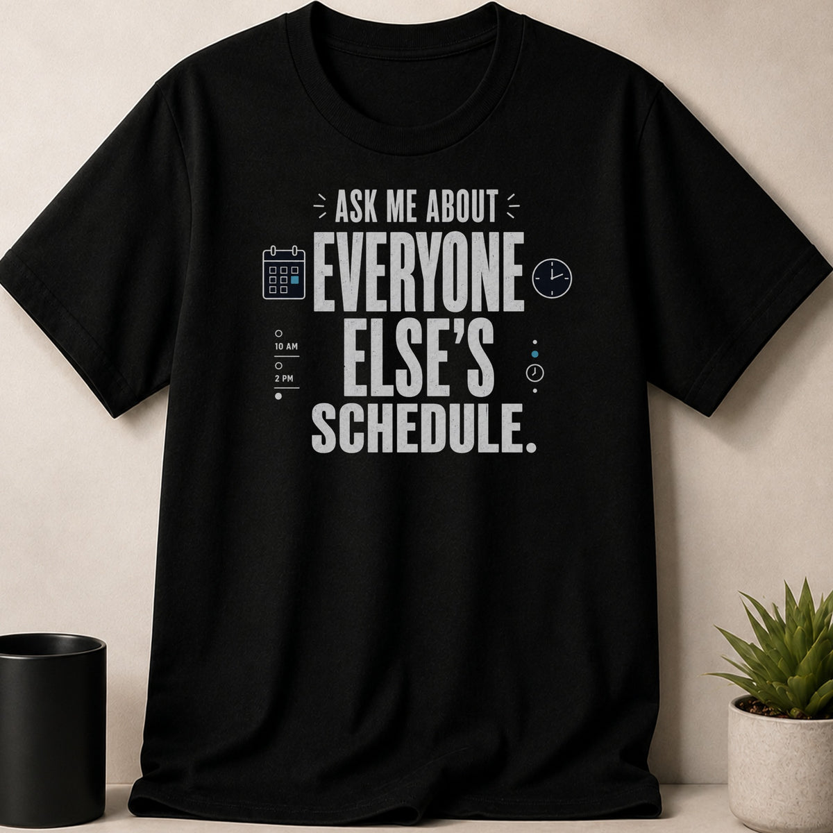 Black t-shirt with "Ask Me About Everyone Else's Schedule" slogan and calendar/clock graphics.