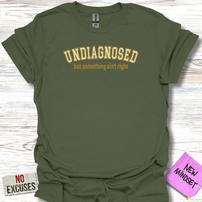 Green t-shirt with "undiagnosed but something ain't right" in yellow text.