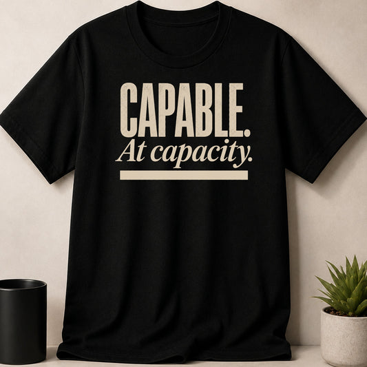 Black t-shirt with "CAPABLE. At capacity." text in cream.