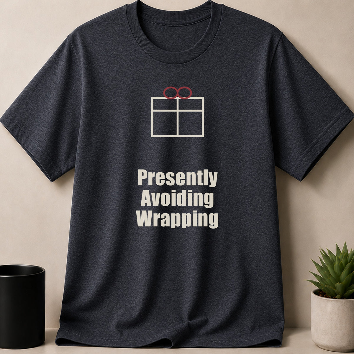 Dark gray short-sleeve t-shirt with a white graphic of a present and the text "Presently Avoiding Wrapping".