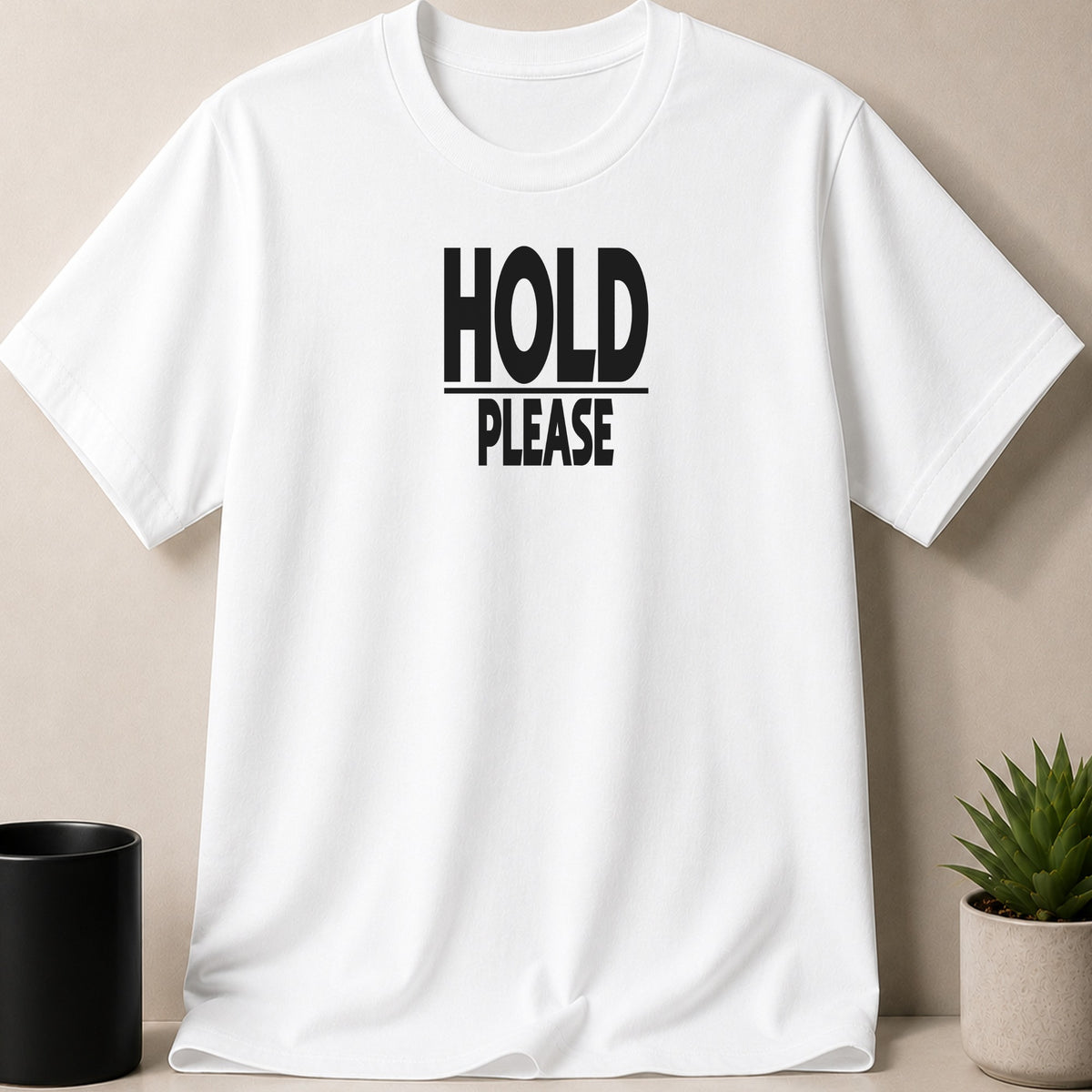 White t-shirt with black text "HOLD PLEASE" printed on the chest.