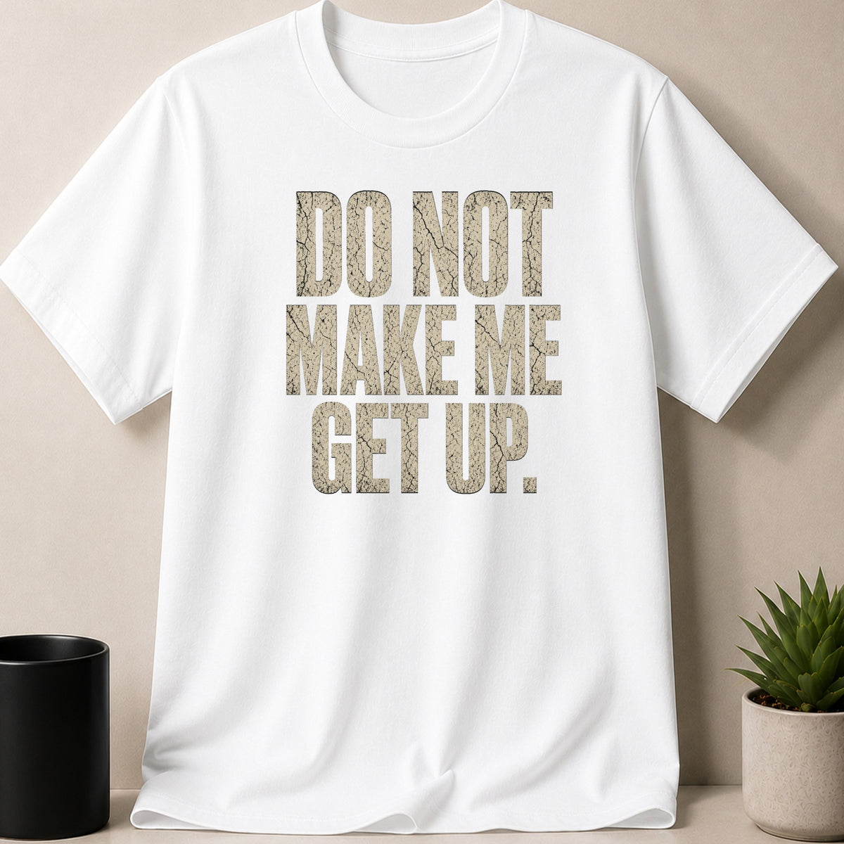 White t-shirt with cracked tan text "DO NOT MAKE ME GET UP."