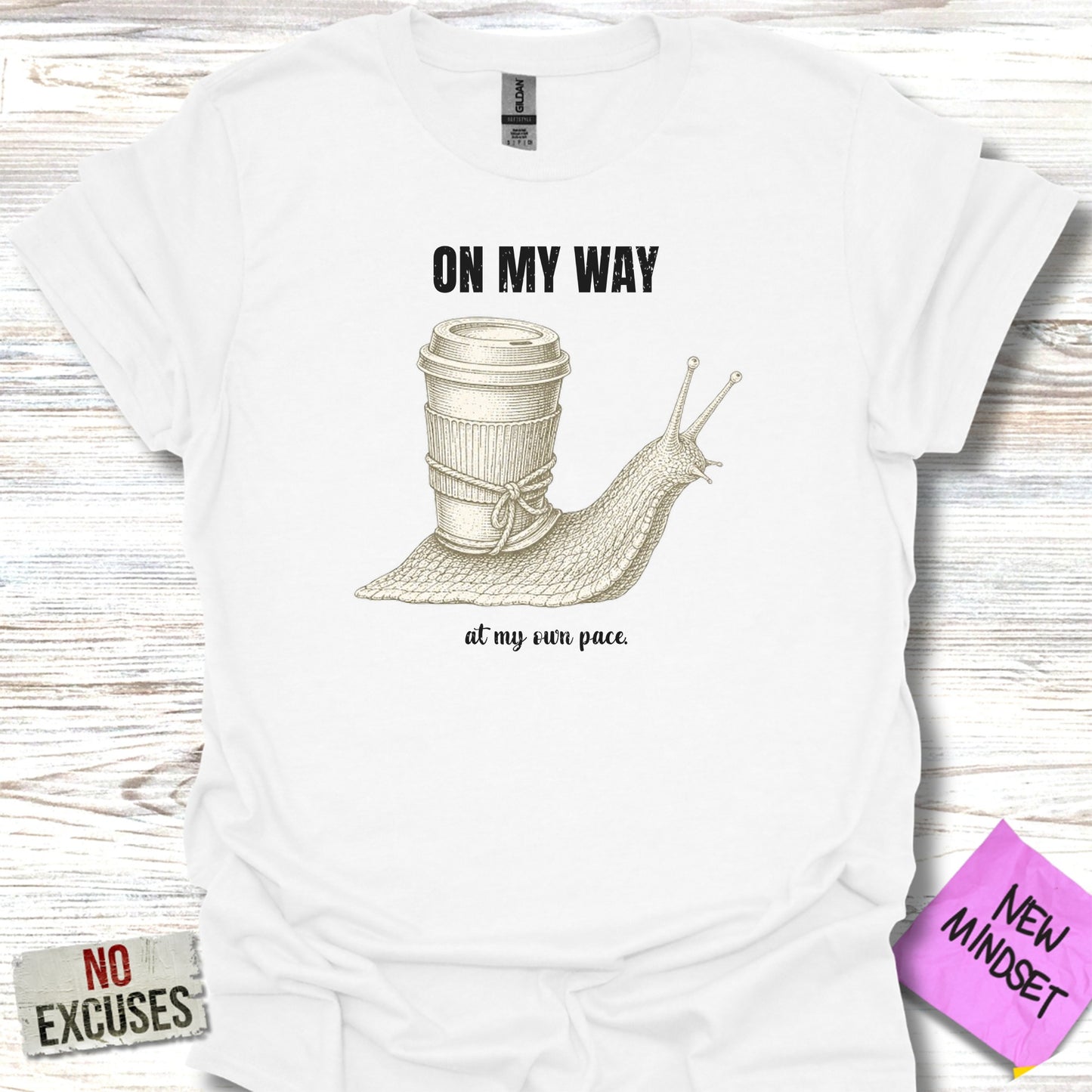 White t-shirt with a snail carrying a coffee cup, text "ON MY WAY" and "at my own pace."