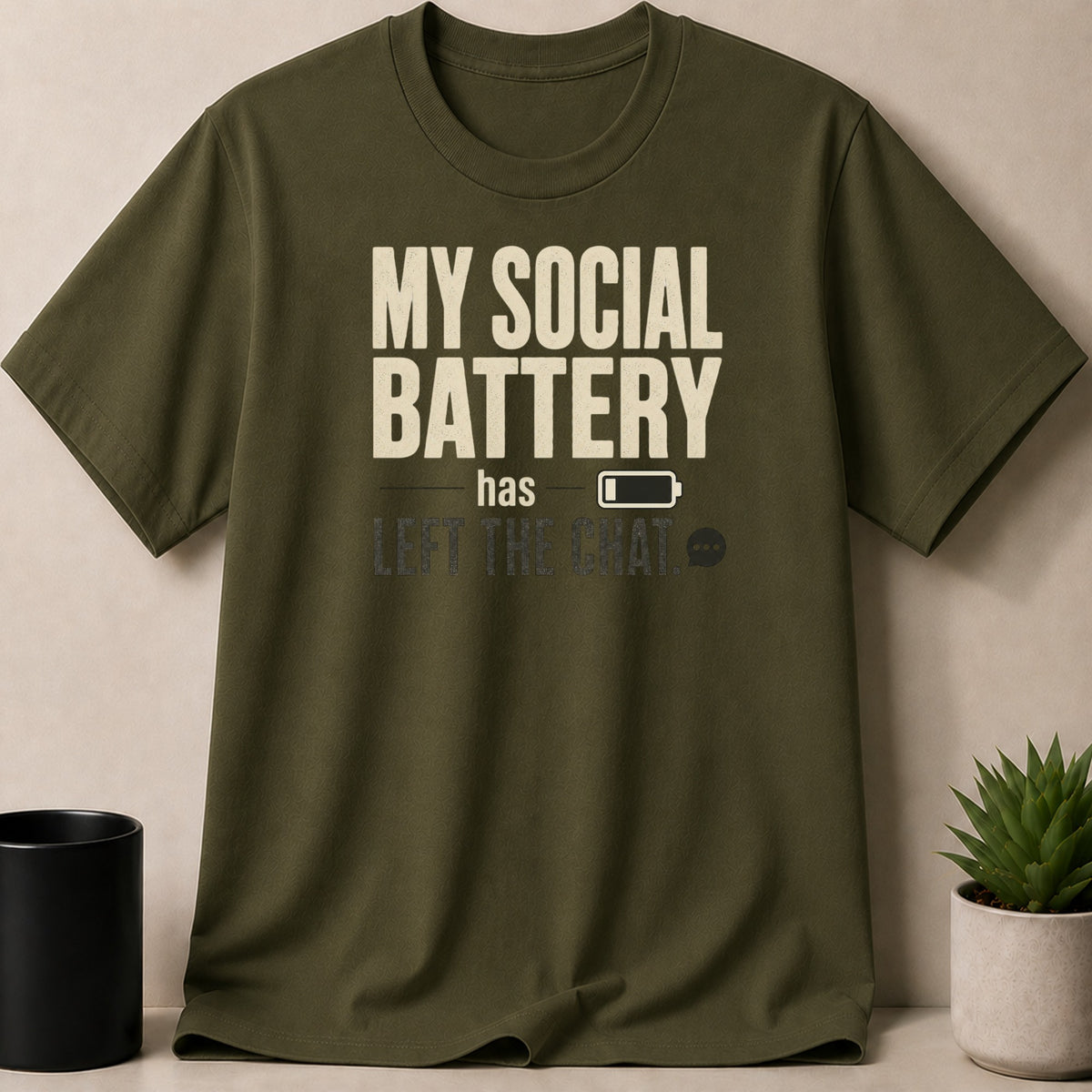Olive green t-shirt with "My social battery has left the chat" graphic.