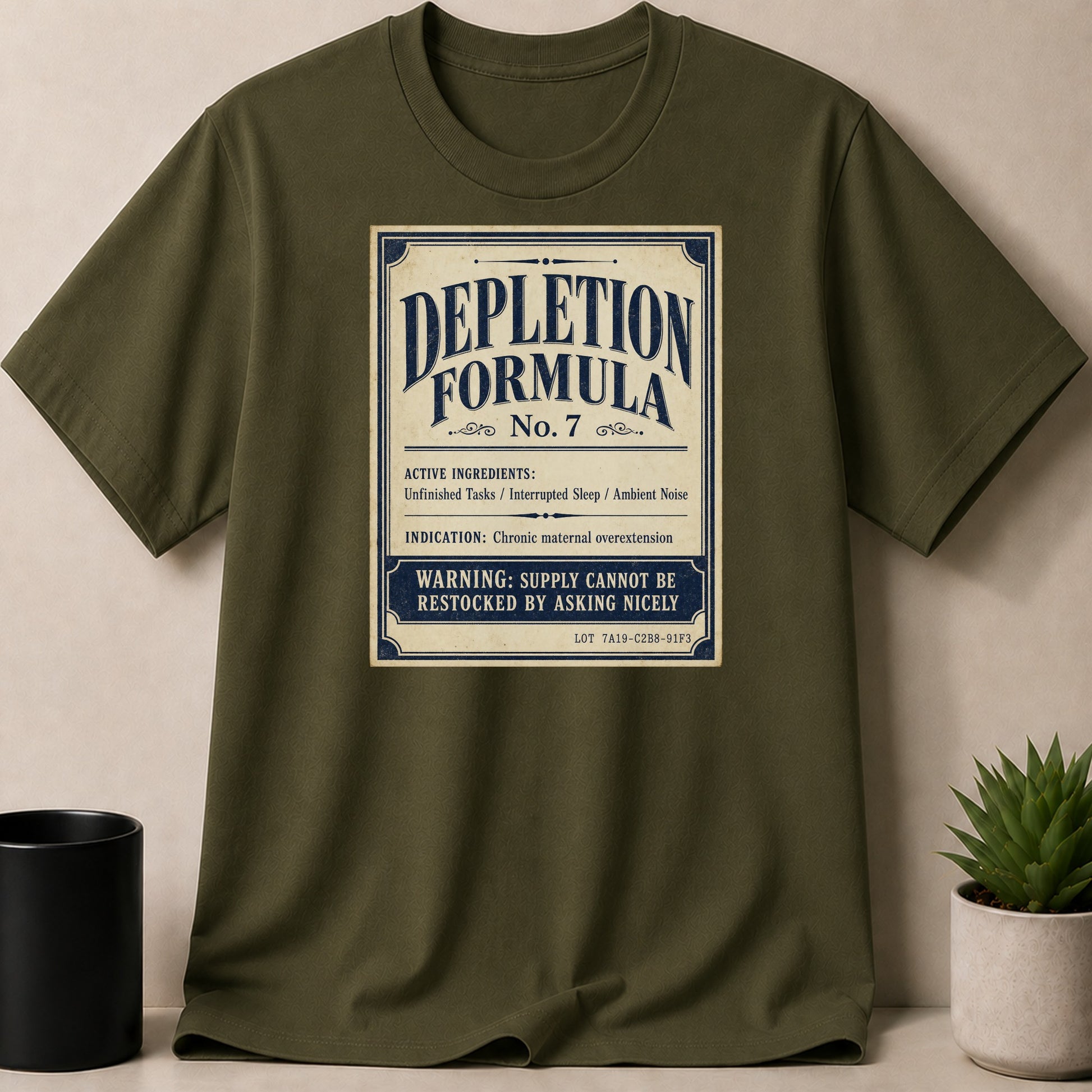 Green t-shirt with "Depletion Formula No. 7" design about maternal overextension.
