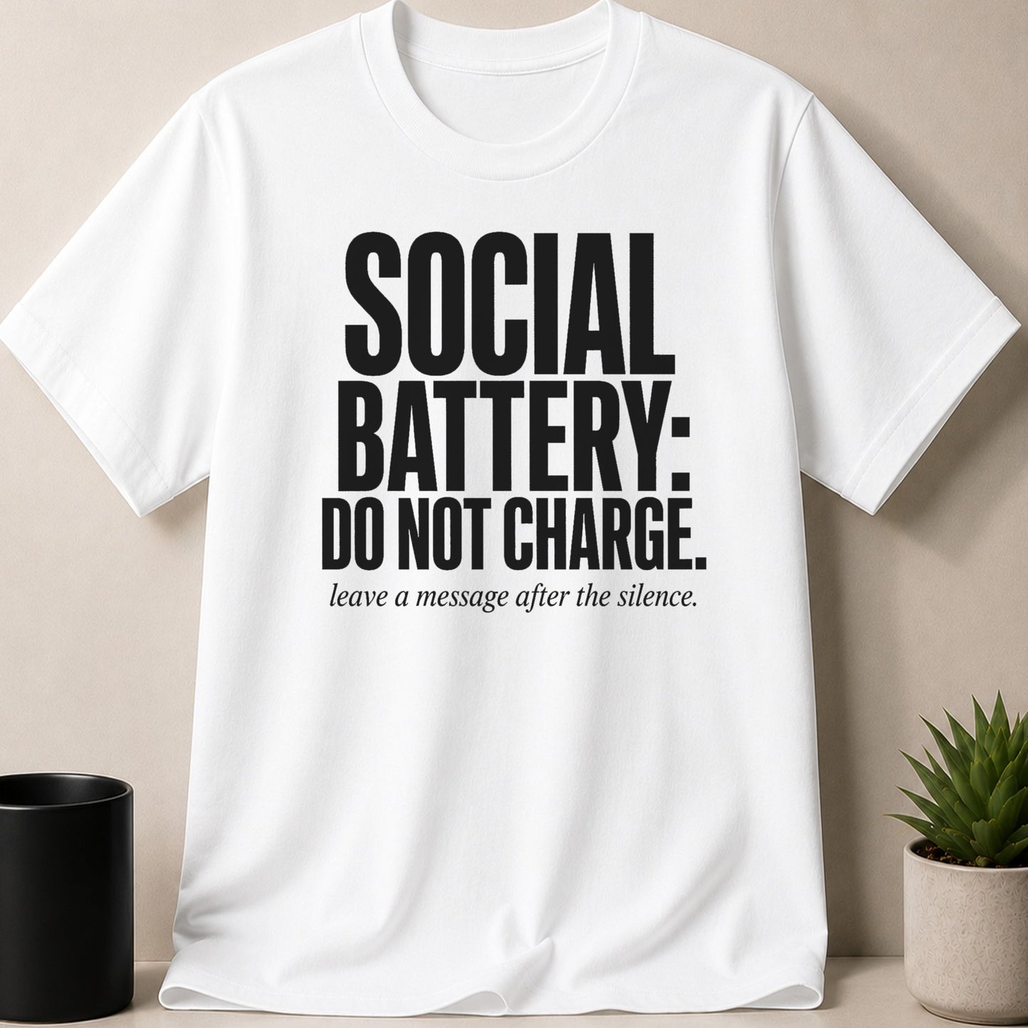 White t-shirt with bold black text: SOCIAL BATTERY: DO NOT CHARGE. leave a message after the silence.