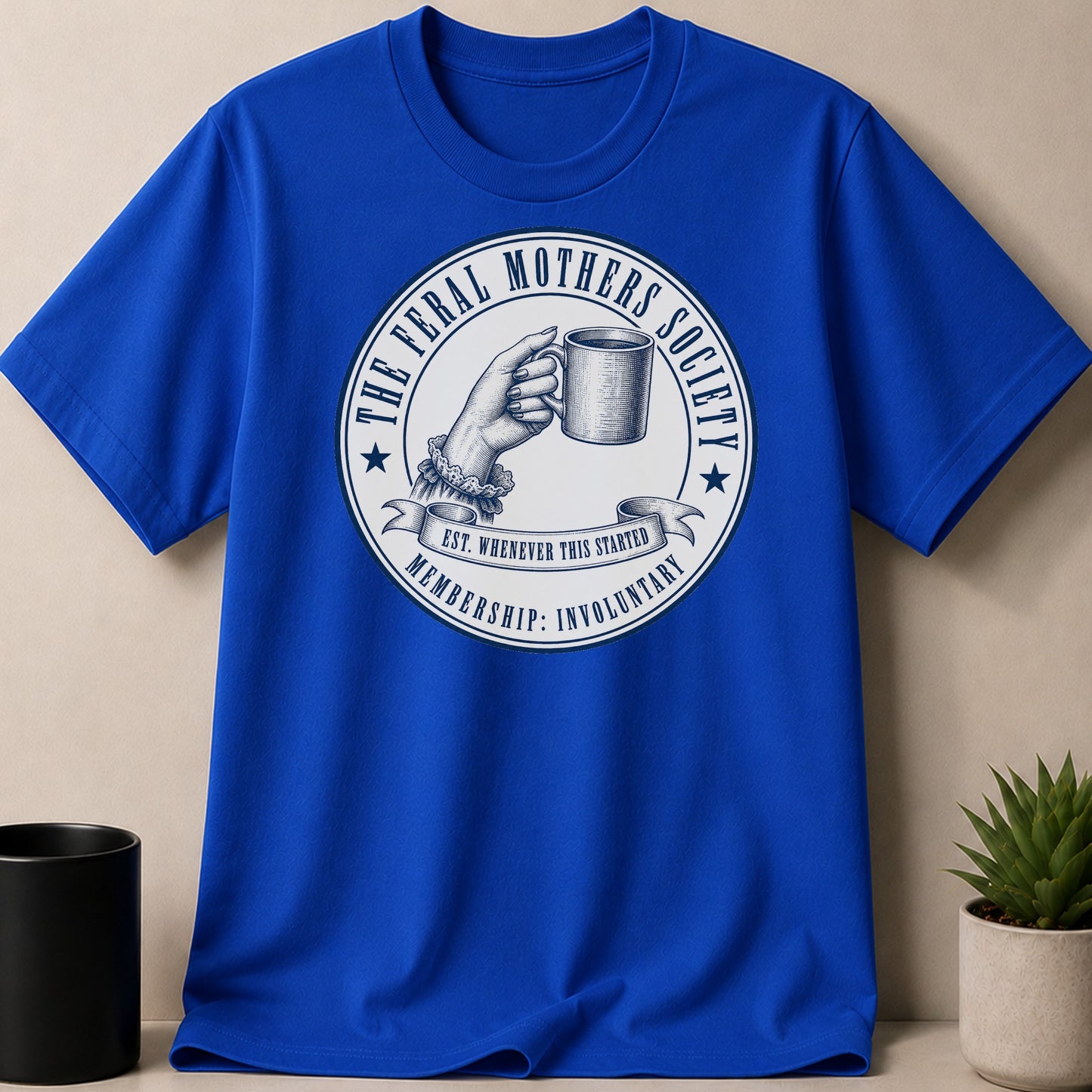Blue t-shirt with "The Feral Mothers Society" logo and "Membership: Involuntary" text.