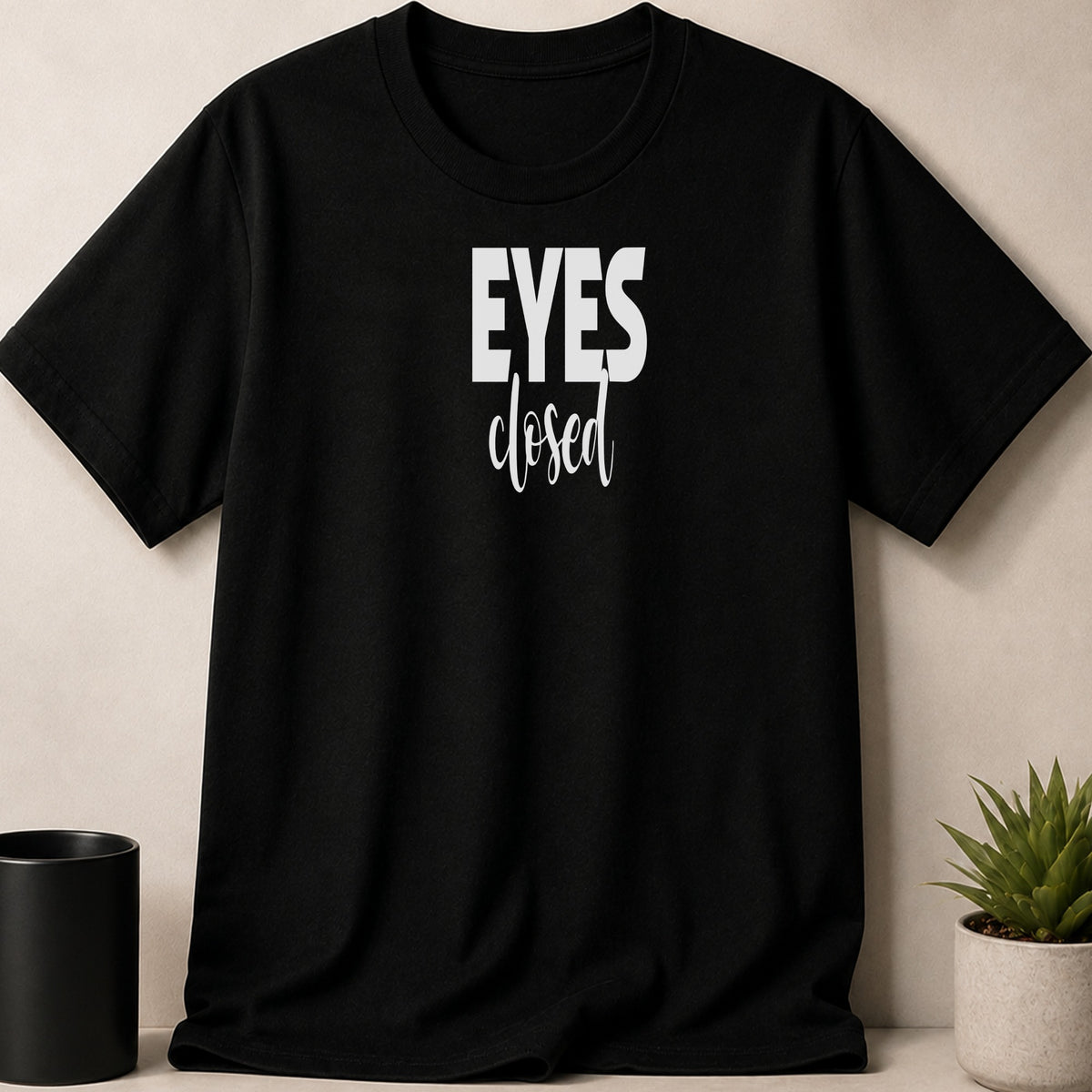 Black t-shirt with white text reading "EYES closed".
