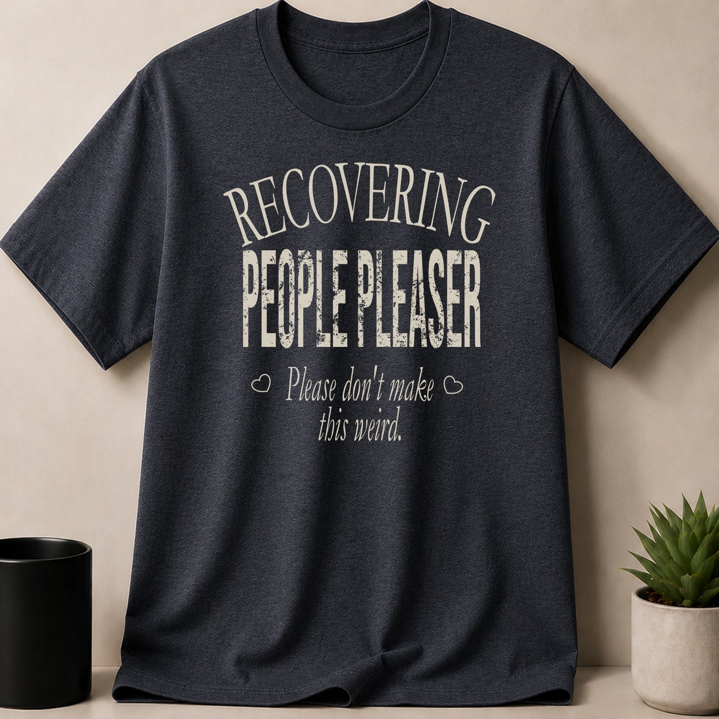 Dark grey t-shirt with "Recovering People Pleaser Please don't make this weird" text.