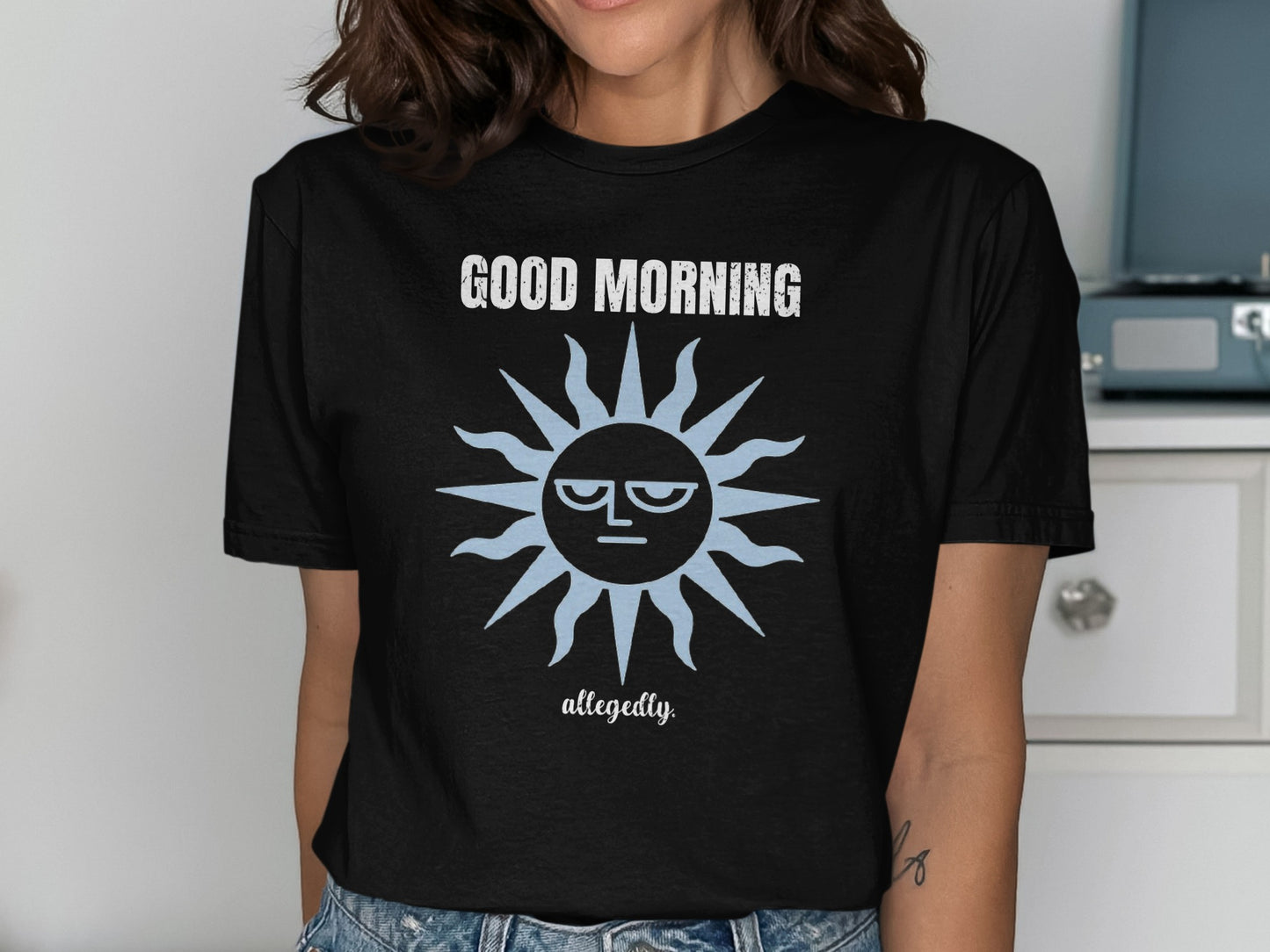 Black t-shirt with "GOOD MORNING allegedly." and a grumpy sun graphic.